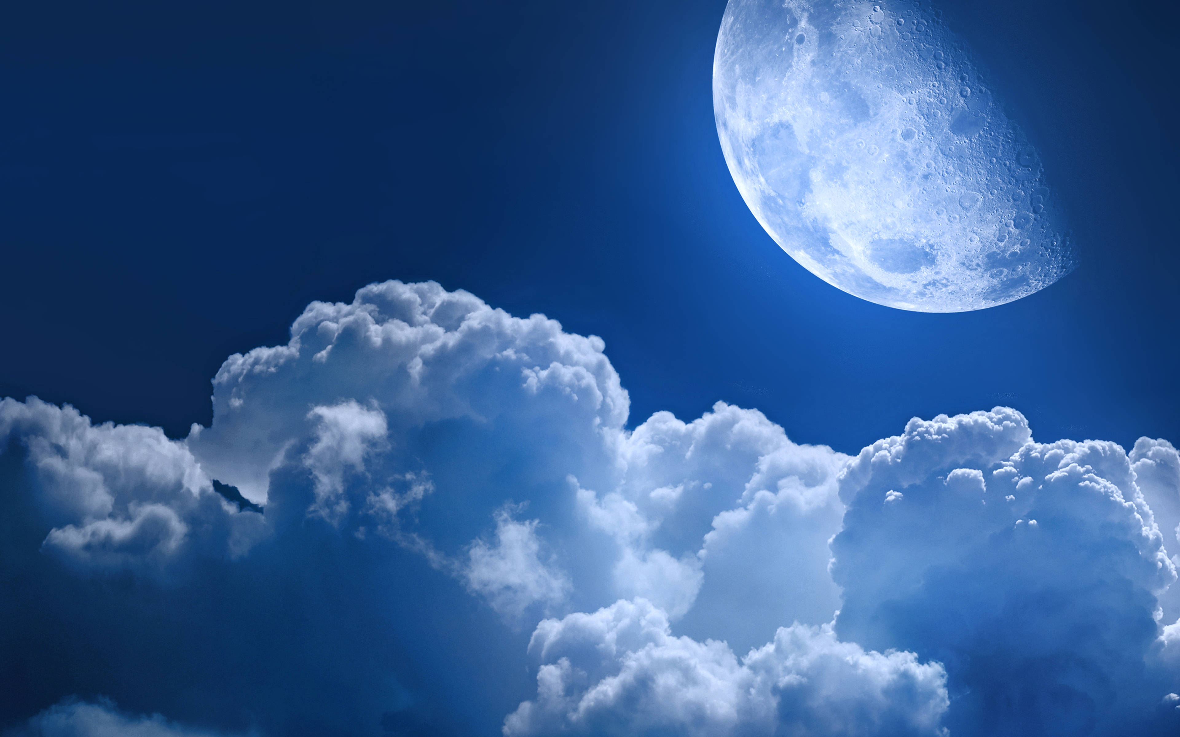 Clouds Aesthetics 桌布 壁紙 — 一輪明亮的彎月在深藍色背景上，佈滿蓬鬆白雲的戲劇性天空中閃耀。