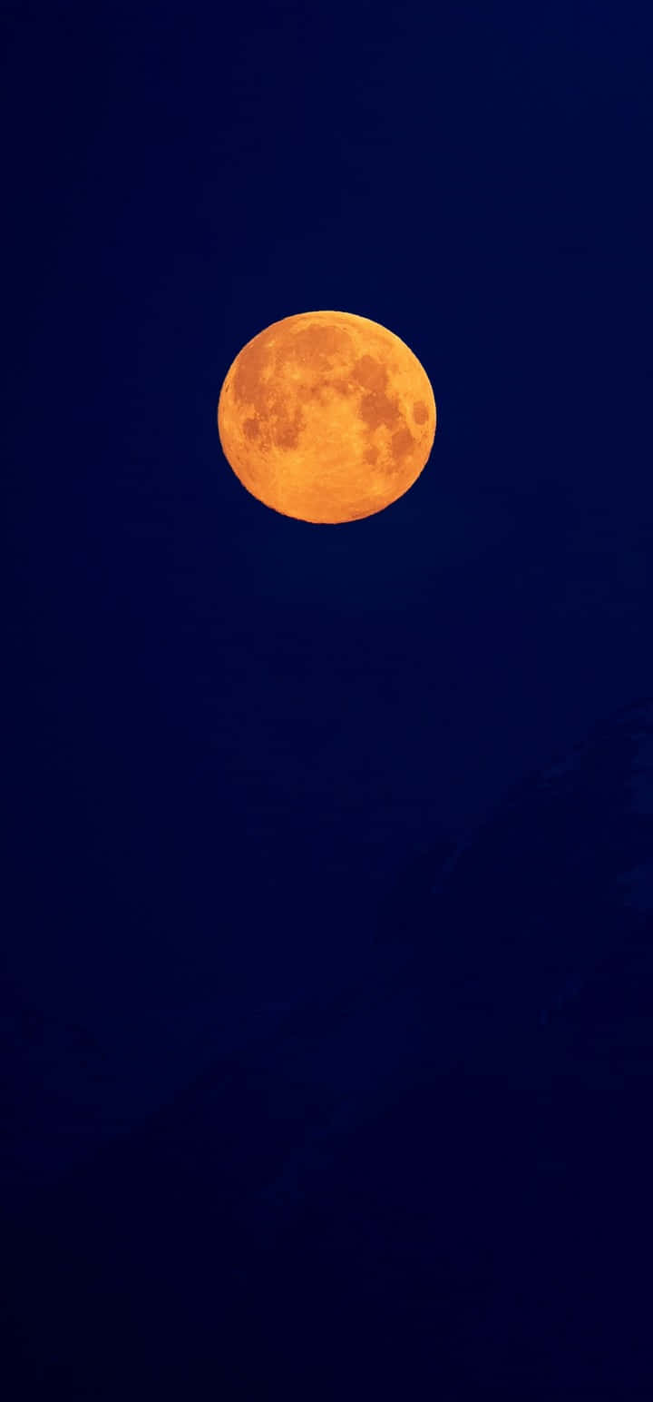 Moon Night 桌布 壁紙 — 一輪明亮的橙色滿月在深靛藍色的夜空中發光，下方有模糊的山脈輪廓。