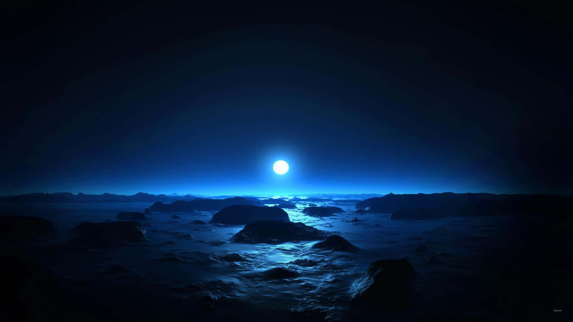Moonlight 桌布 壁紙 — 一輪明亮的滿月在夜間為崎嶇、霧氣瀰漫的海洋景觀投下空靈的藍色光芒。