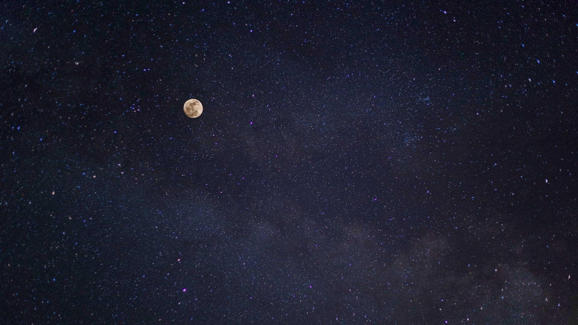 full moon 桌布 壁紙 — 一輪明亮的滿月在深邃的靛藍色夜空中，在密集的星群和宇宙塵埃中閃耀。