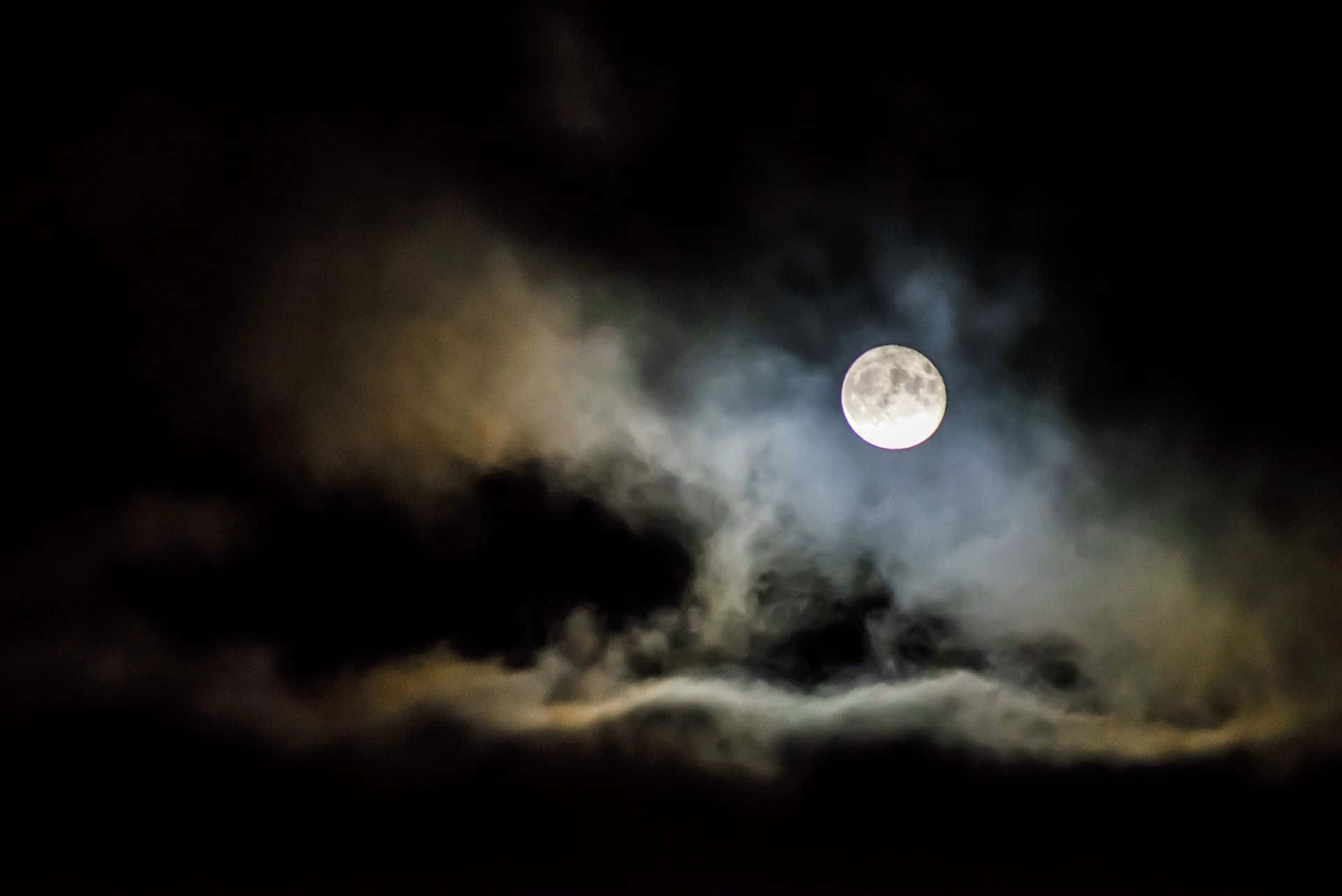 Dark Moon 桌布 壁紙 — 一輪明亮的滿月穿透旋轉的烏雲，在戲劇性的夜空中閃耀。