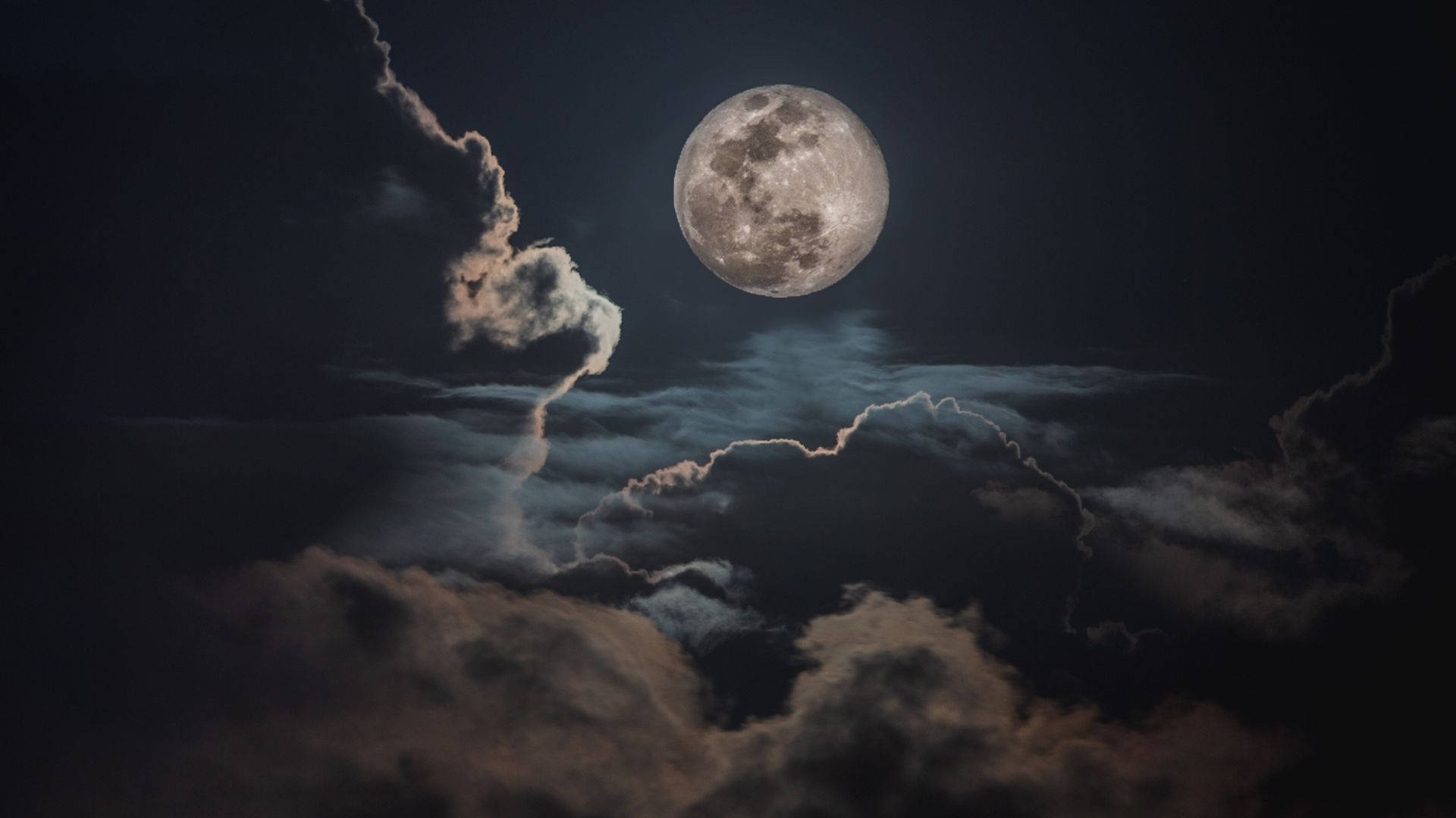 雲朵 桌布 壁紙 — 一輪明亮的滿月穿過戲劇性的烏雲，在充滿氛圍的夜空中閃耀。