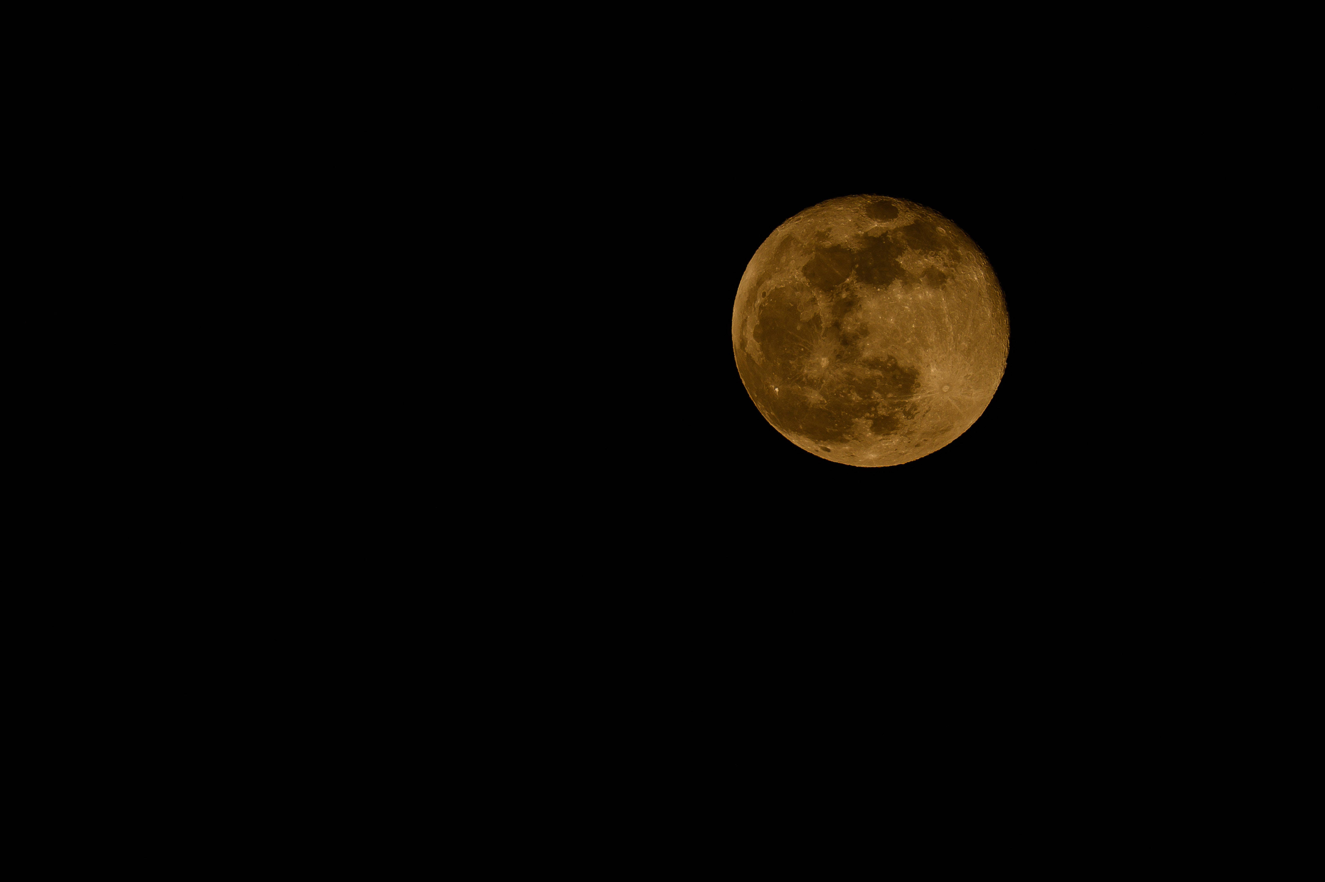 full moon 桌布 壁紙 — 一輪明亮的琥珀色滿月在沒有星星的漆黑夜空中發光。