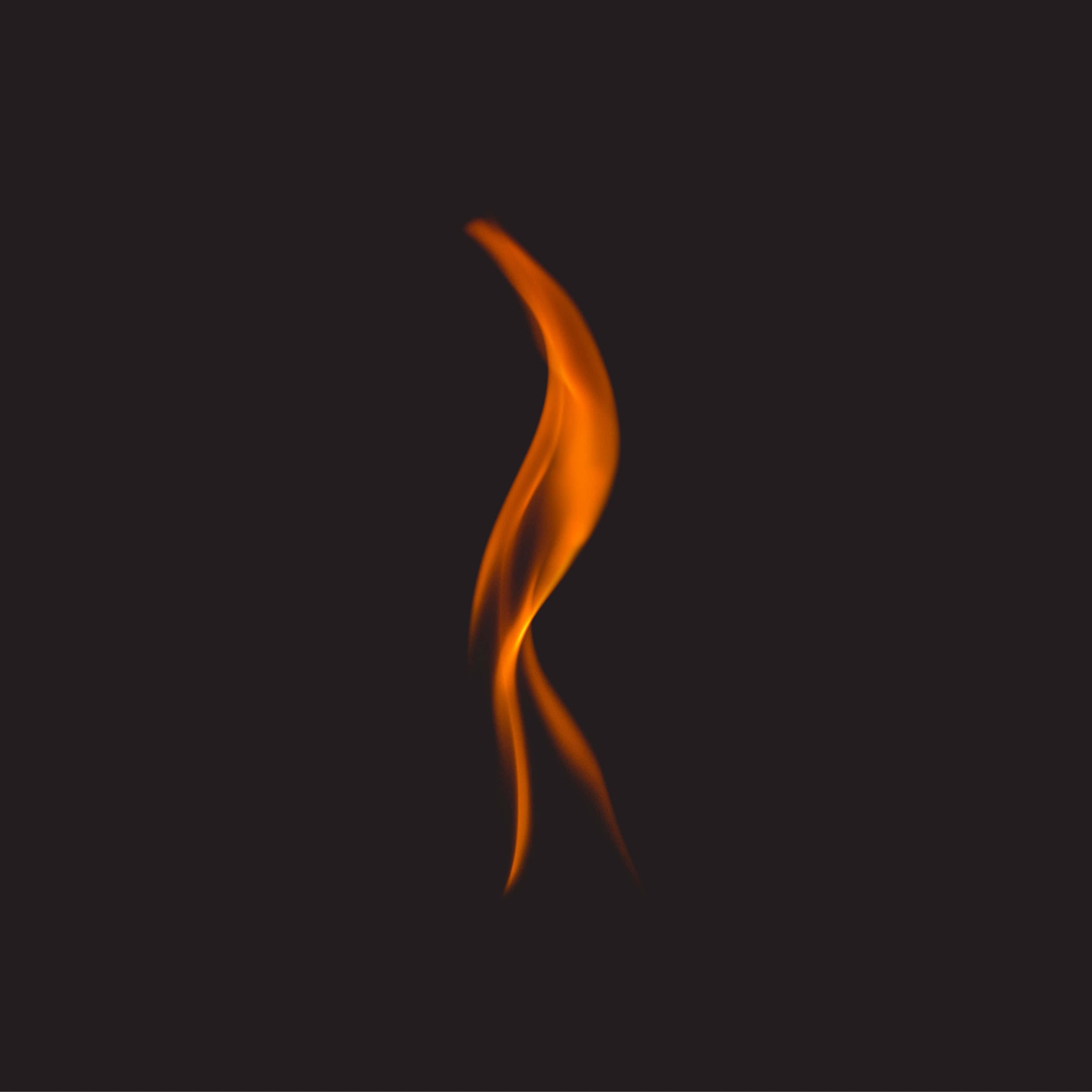 Flames 桌布 壁紙 — 一道優雅的火焰在深邃的黑色背景上向上彎曲，散發著溫暖的橙色和黃色光芒。