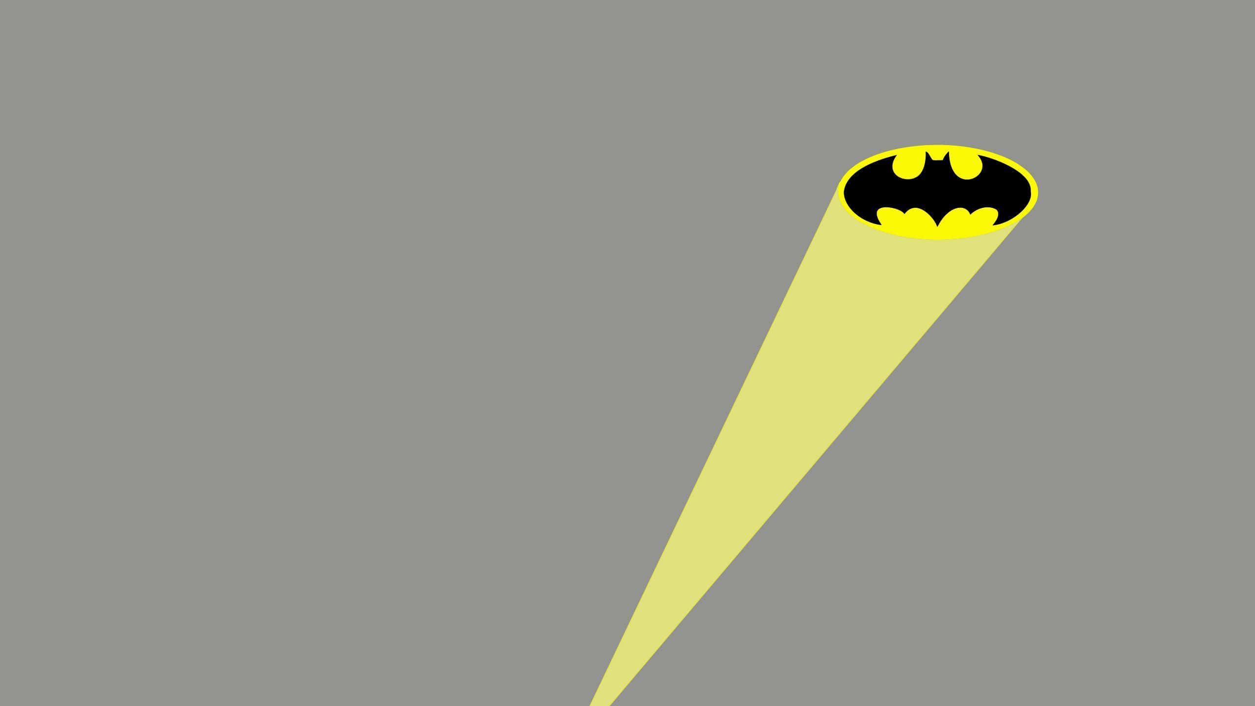 Bat Signal 桌布 壁紙 — 一道大膽的黃色聚光燈從左下角照射，在純灰色背景上形成黑黃色的蝙蝠俠標誌。