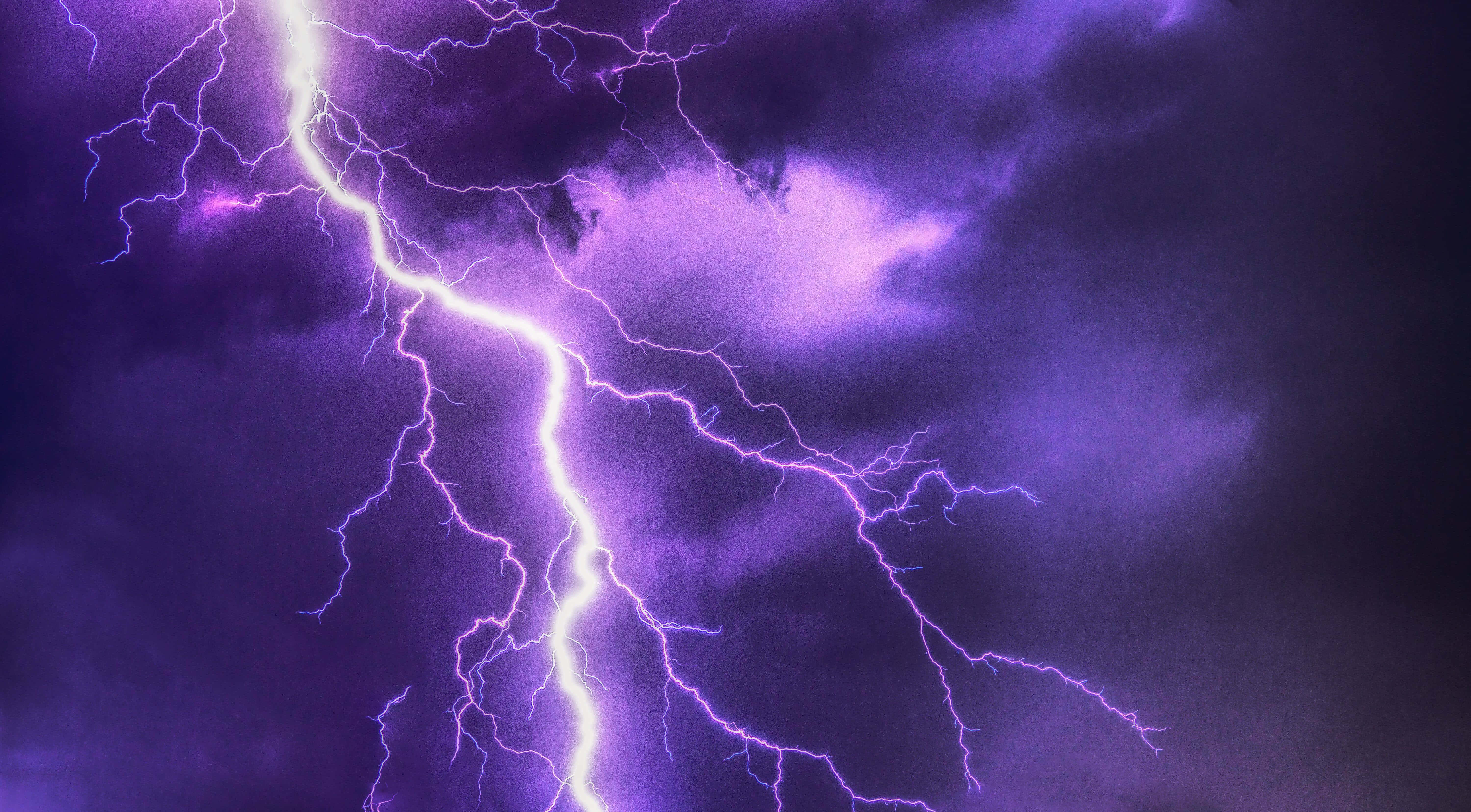 Purple Lightning 桌布 壁紙 — 一道強勁的紫色閃電在佈滿烏雲的暴風雨中分叉劃過天空。
