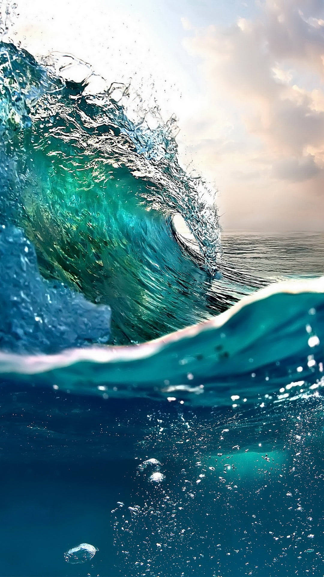 波浪 桌布 壁紙 — 一道強勁的藍綠色海浪在頭頂翻捲，陽光照射的水花飛濺，映襯著柔和的金色天空。