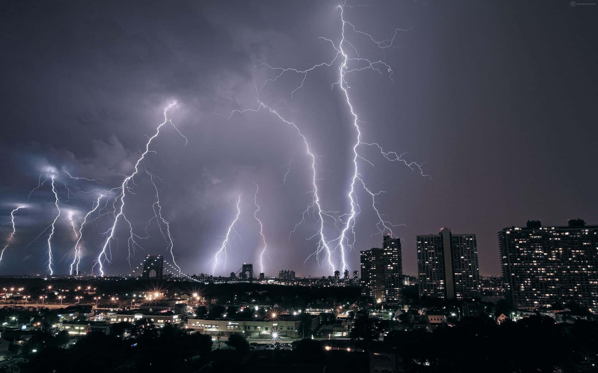夜間城市上空的強烈閃電，照亮建築物和橋樑。