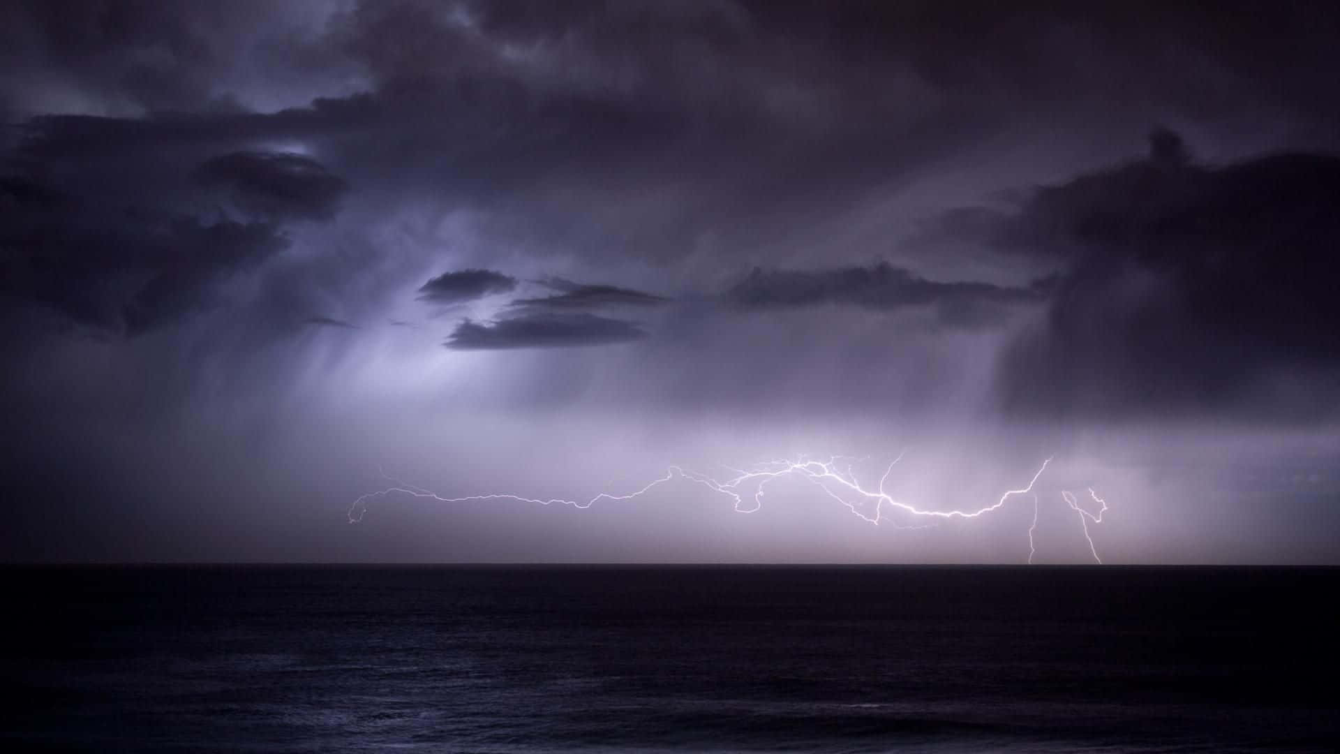 Thunderstorm 桌布 壁紙 — 一道強大的閃電劃過暴風雨中的海洋，天空呈深紫色。