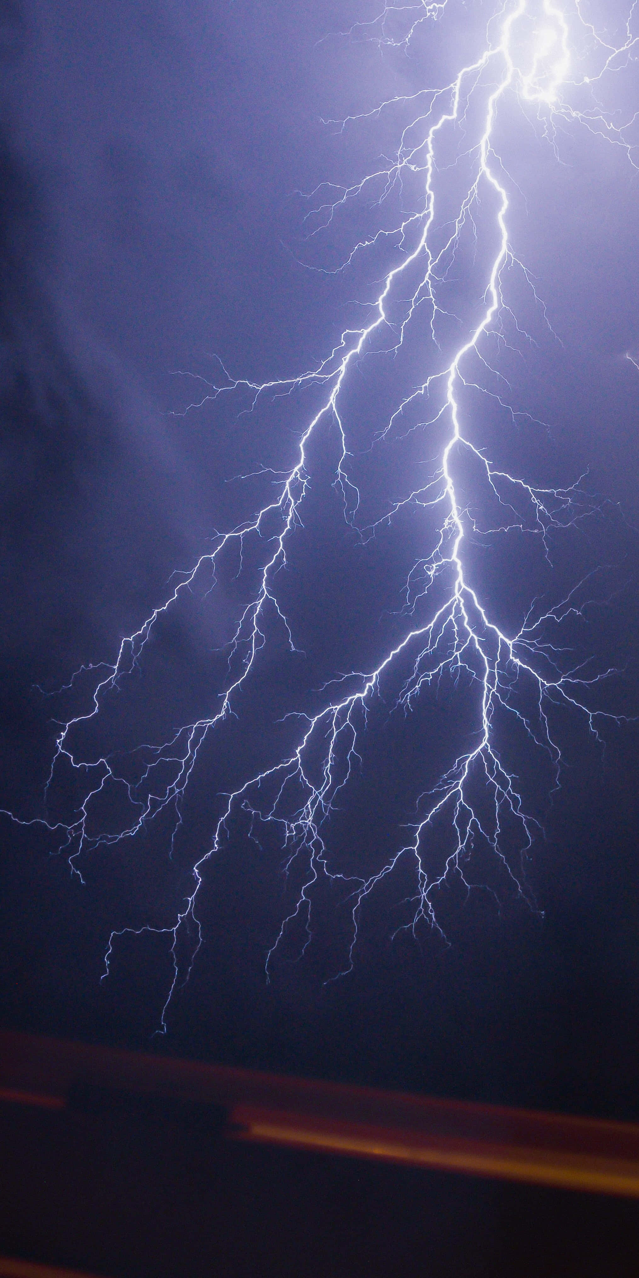 Dark Storm 桌布 壁紙 — 一道強大的閃電在黑暗的暴風雨天空中分叉，電光藍白能量照亮雲層。