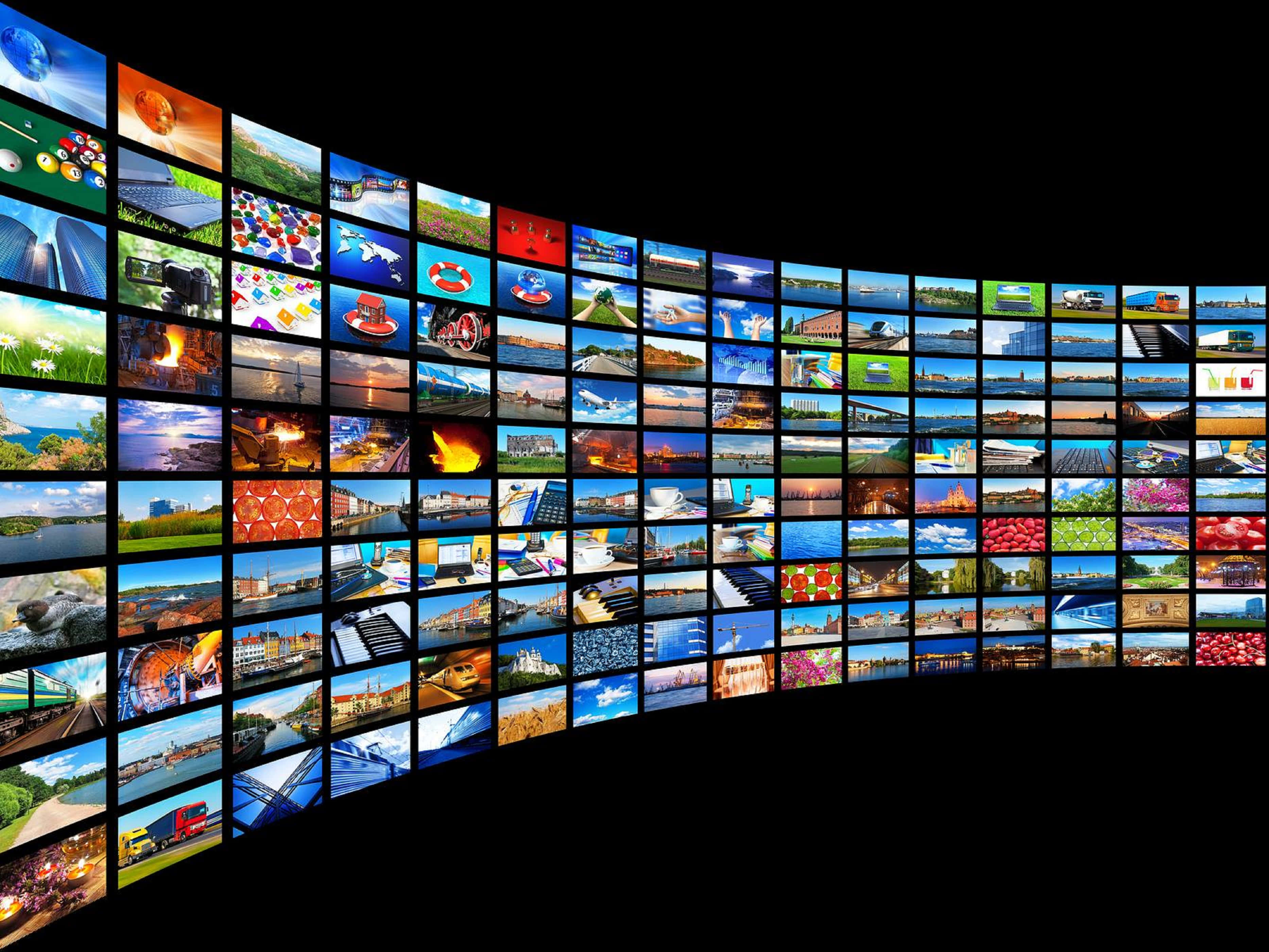 4K Streaming 桌布 壁紙 — 一道彎曲的發光屏幕牆，在黑色虛空背景下展示從自然到城市生活的多樣全球場景的鮮明拼貼畫。