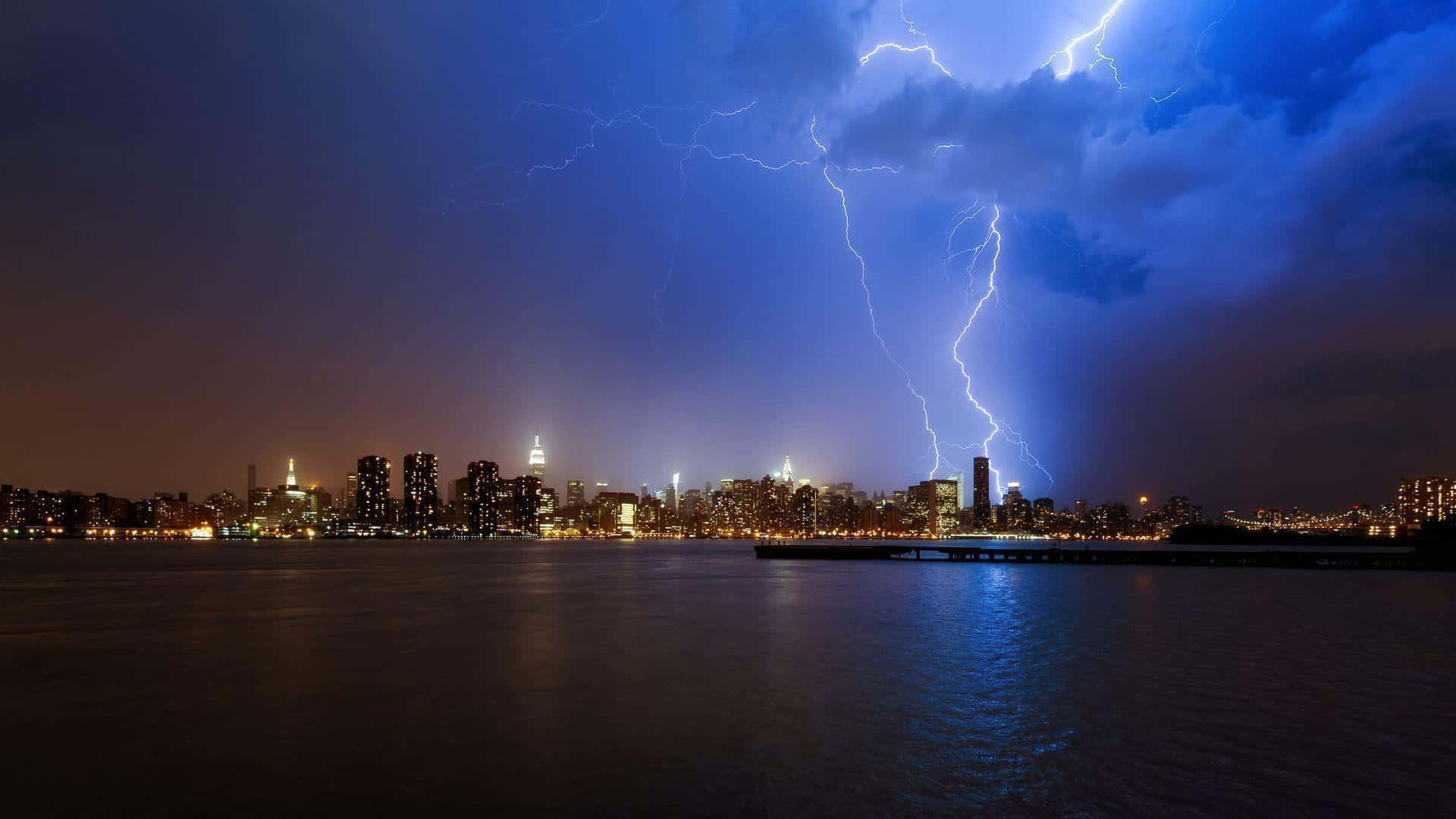 thunder 桌布 壁紙 — 一道戲劇性的閃電照亮了暴風雨之夜，城市天際線在黑暗的水面上閃爍倒映。