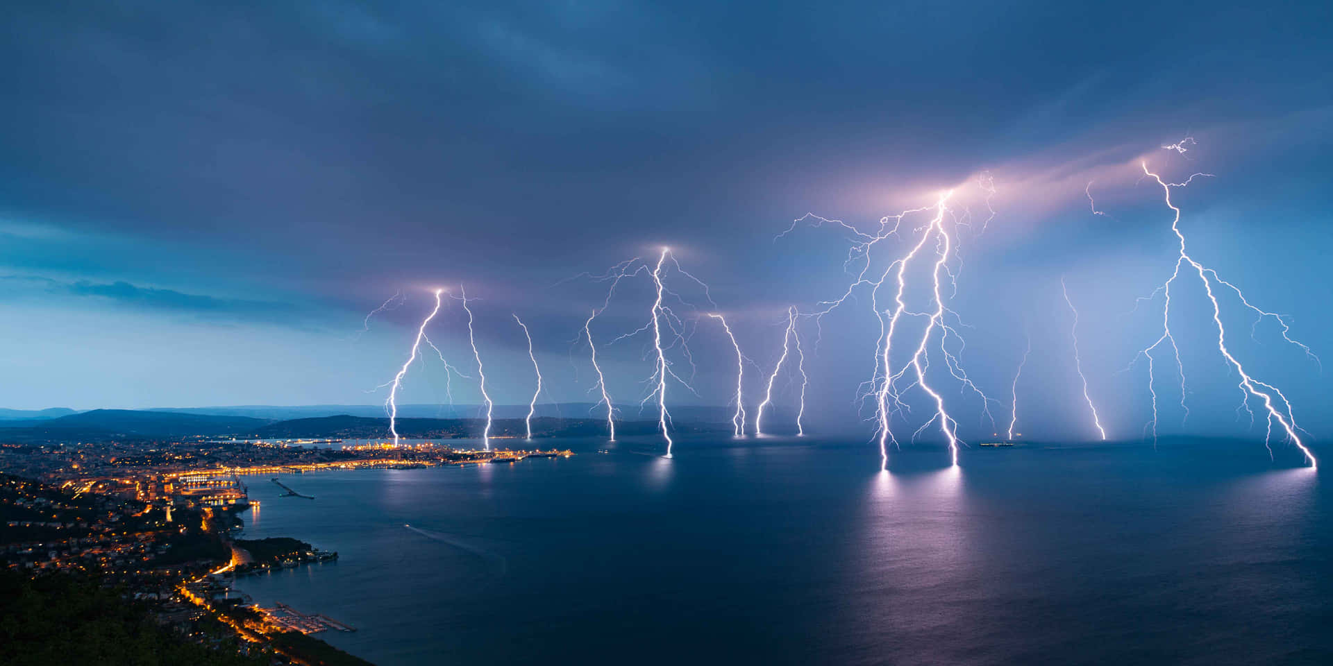 夜間沿海城市上空的戲劇性閃電。