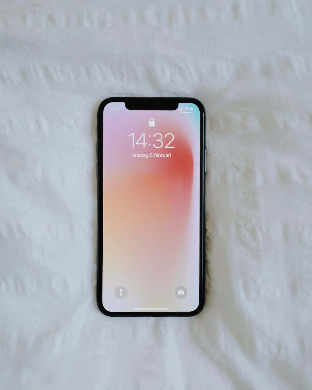 一部iPhone X放在床上 壁紙
