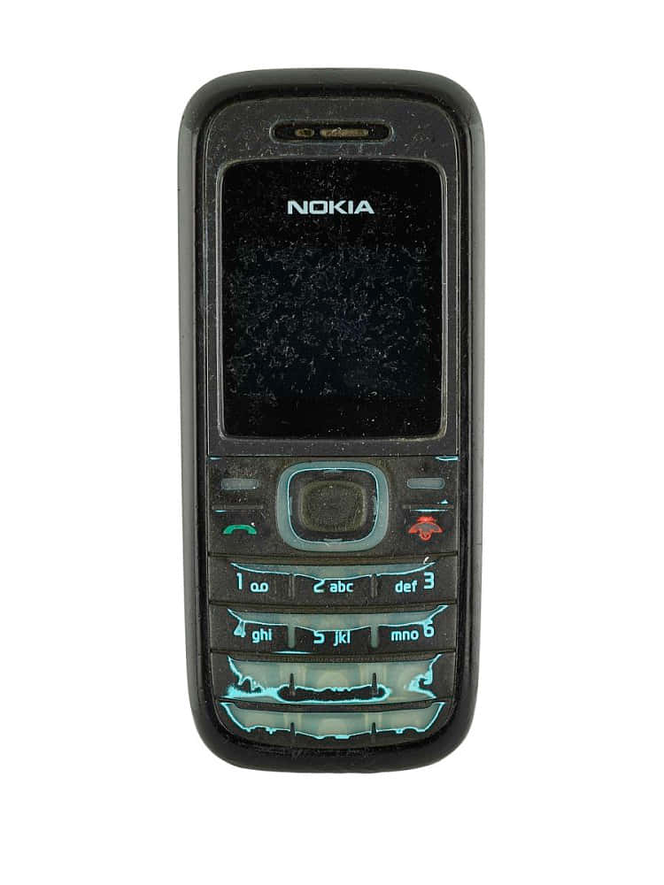 Nokia 桌布 壁紙 — 一部使用痕跡明顯的黑色 Nokia 手機，螢幕破裂，藍色鍵盤按鍵發光，背景為白色。