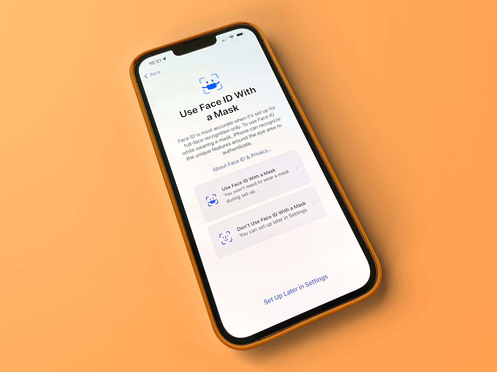 Face Id 桌布 壁紙 — 一部帶有橙色保護殼的智能手機在純橙色背景上顯示 Face ID 設定畫面。