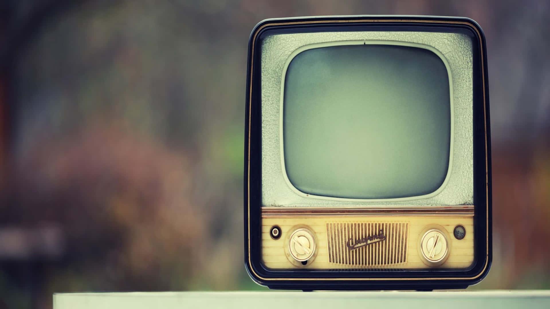 Television Set 桌布 壁紙 — 一部帶有空白屏幕的復古電視機放置在窗台上，背景是柔和模糊的秋日景色。