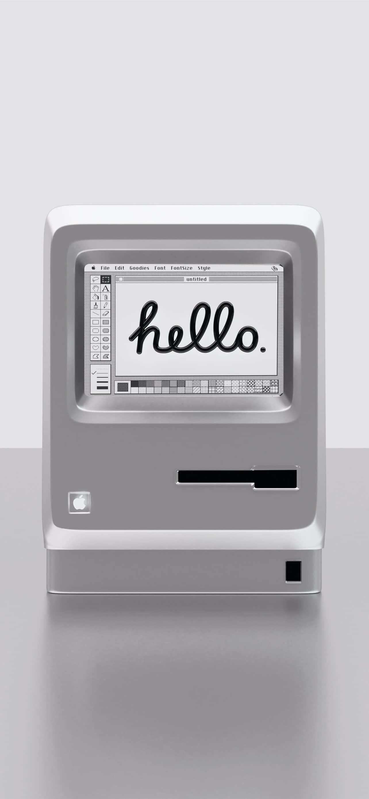 Electronics 桌布 壁紙 — 一部復古銀色 iMac G3 電腦在極簡灰色背景上，以手寫字體在螢幕上顯示「hello」一詞。