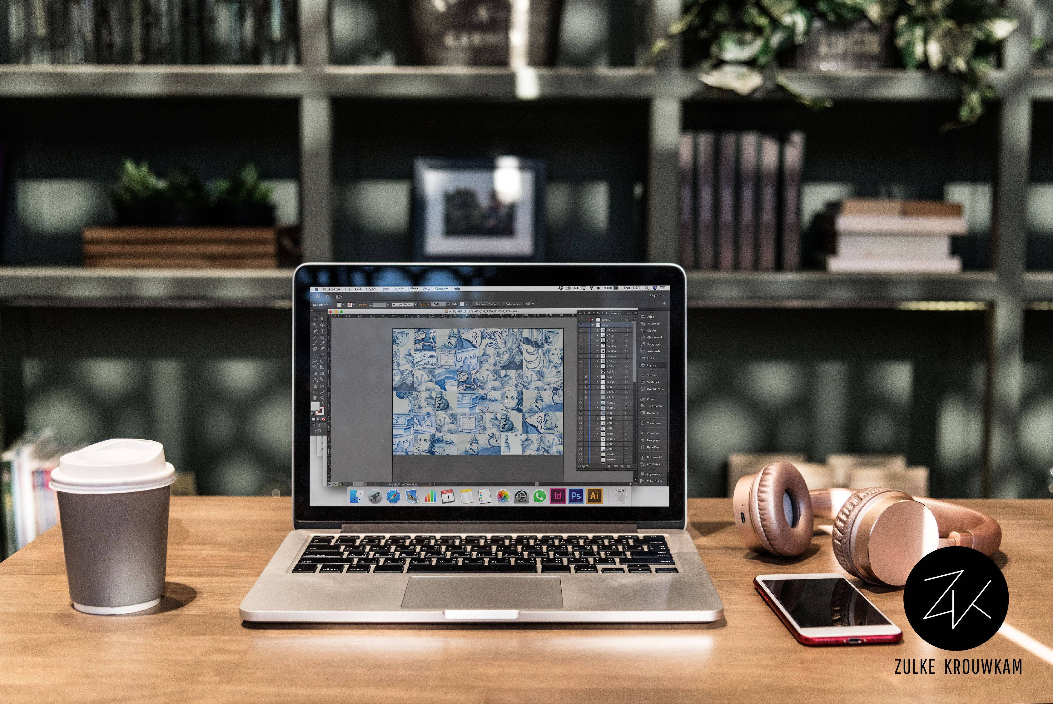 Best Laptop 桌布 壁紙 — 一部手提電腦在木桌上顯示漫畫面板，旁邊有咖啡杯、玫瑰金色耳機和智能手機。