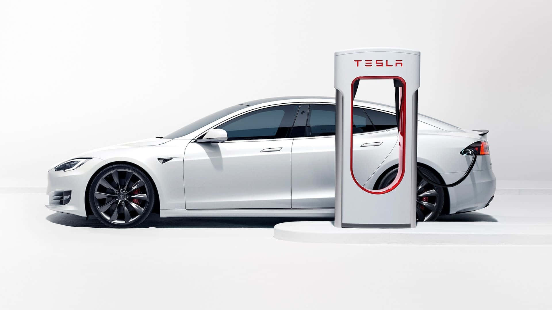 Hybrid Car 桌布 壁紙 — 一部時尚的銀色 Tesla Model S 在簡約的白色工作室背景下插入白色 Tesla Supercharger。