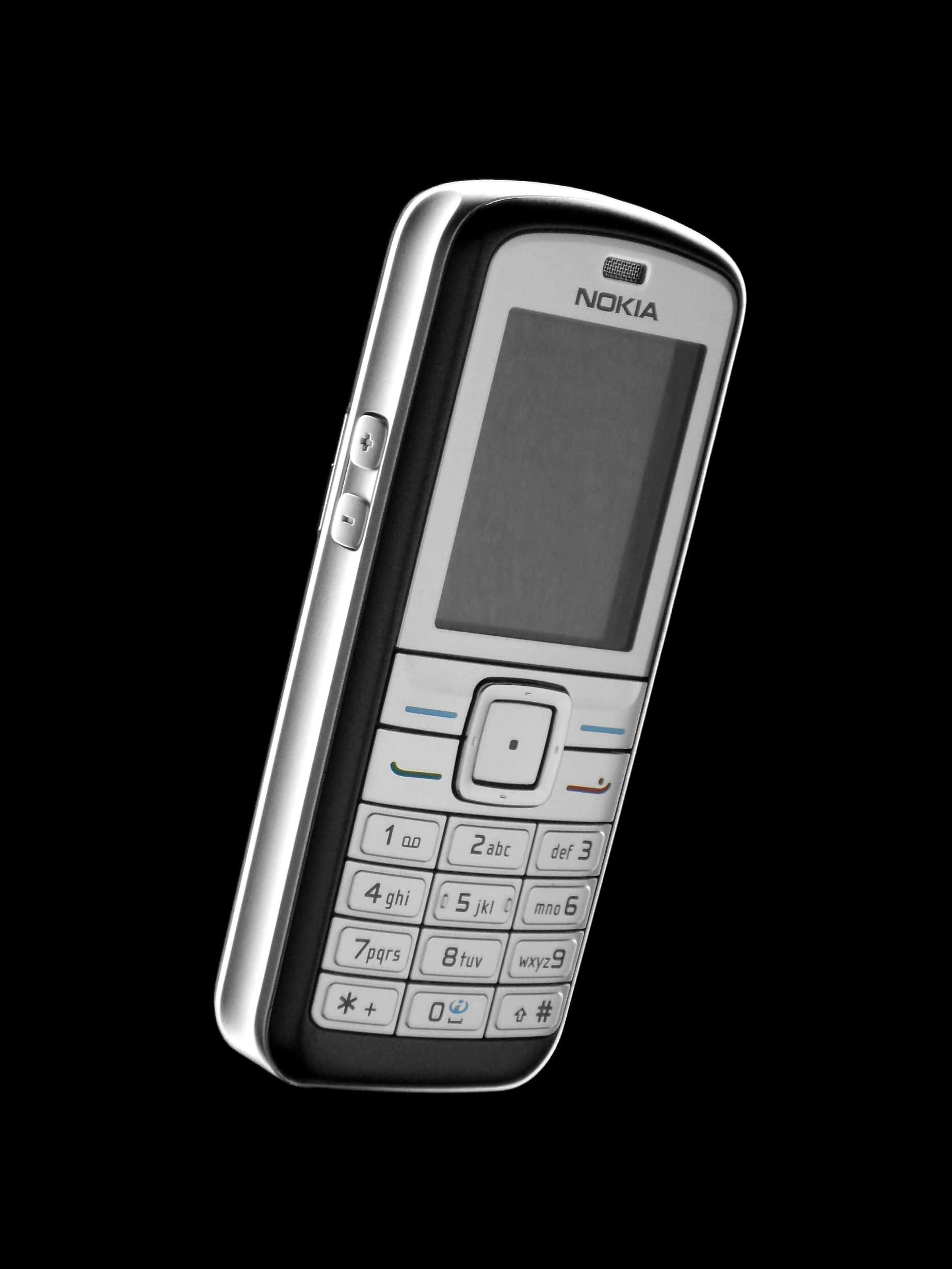 Nokia 桌布 壁紙 — 一部時尚的銀色Nokia功能手機，帶有實體鍵盤和小屏幕，孤立在純黑色背景上。