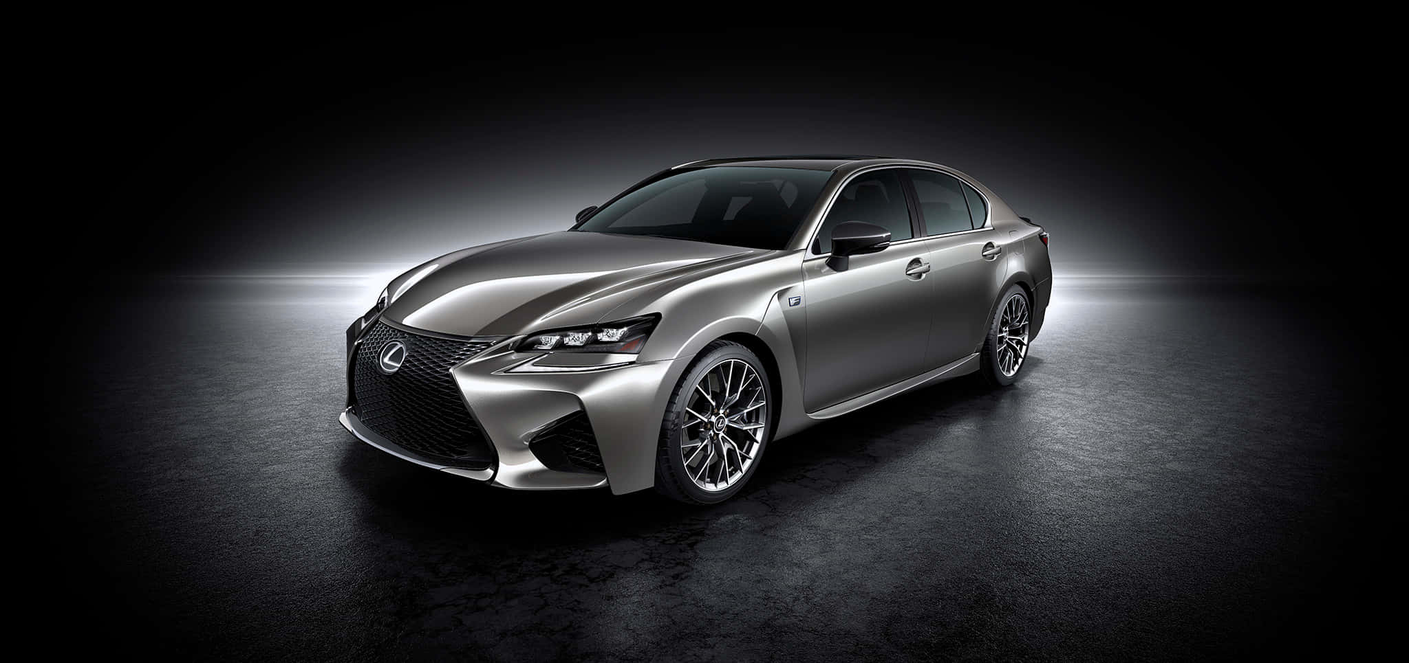 Lexus Gs F 桌布 壁紙 — 一部時尚的銀色凌志房車在戲劇性的攝影棚燈光下，在深色紋理地板上閃閃發光。