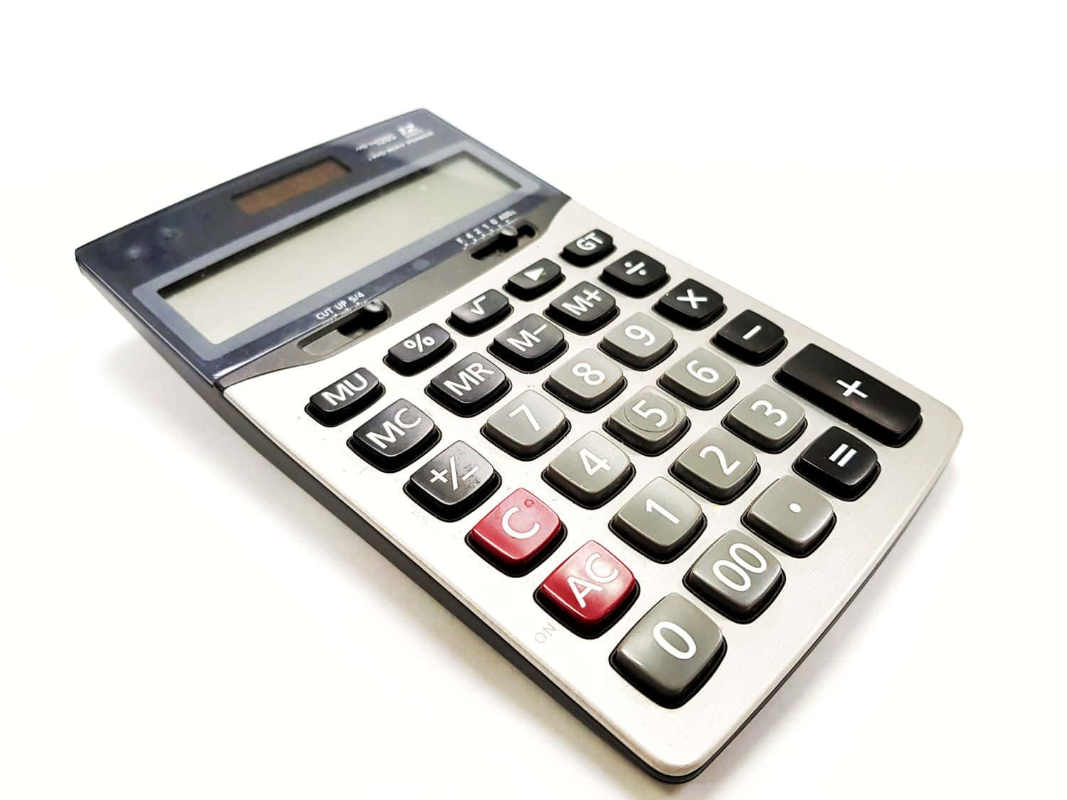 Calculator 桌布 壁紙 — 一部時尚的銀色計算機，帶有黑色和紅色按鈕，放置在乾淨的白色表面上，傾斜角度以便清晰看到鍵盤和顯示屏。