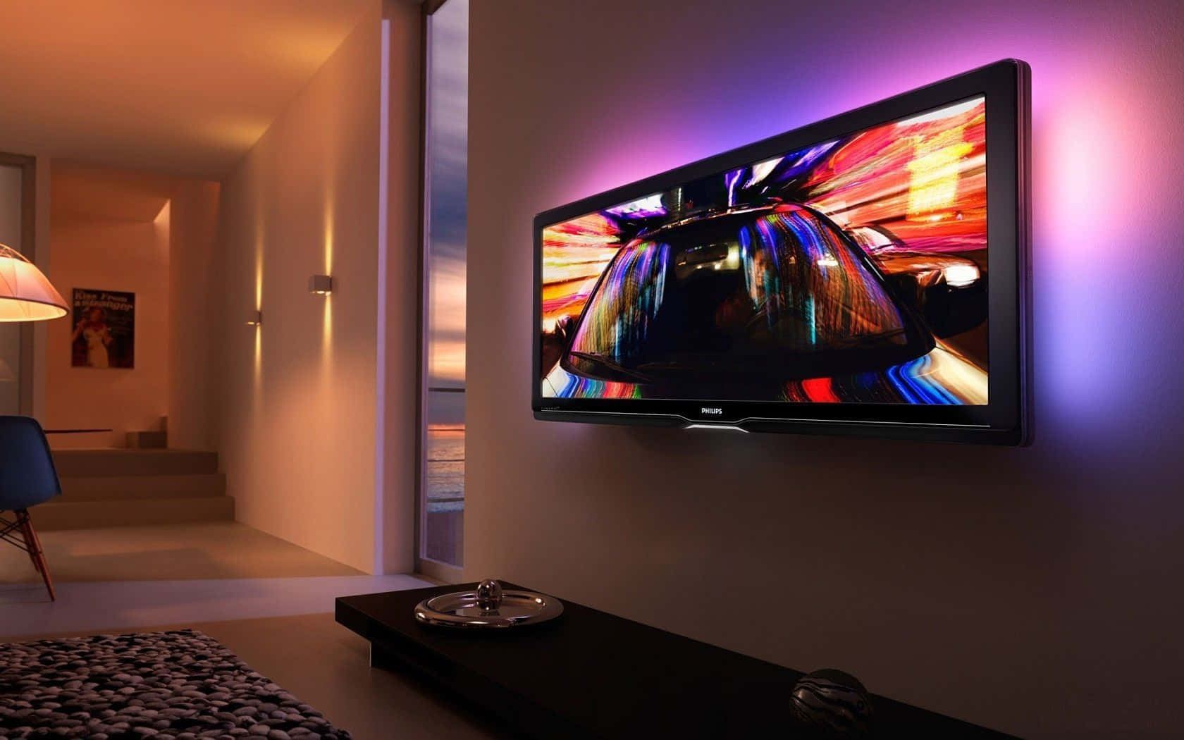Home Cinema 桌布 壁紙 — 一部時尚的電視掛在牆上，顯示充滿活力的抽象汽車場景，而環境紫色燈光在現代客廳中投射出光芒。