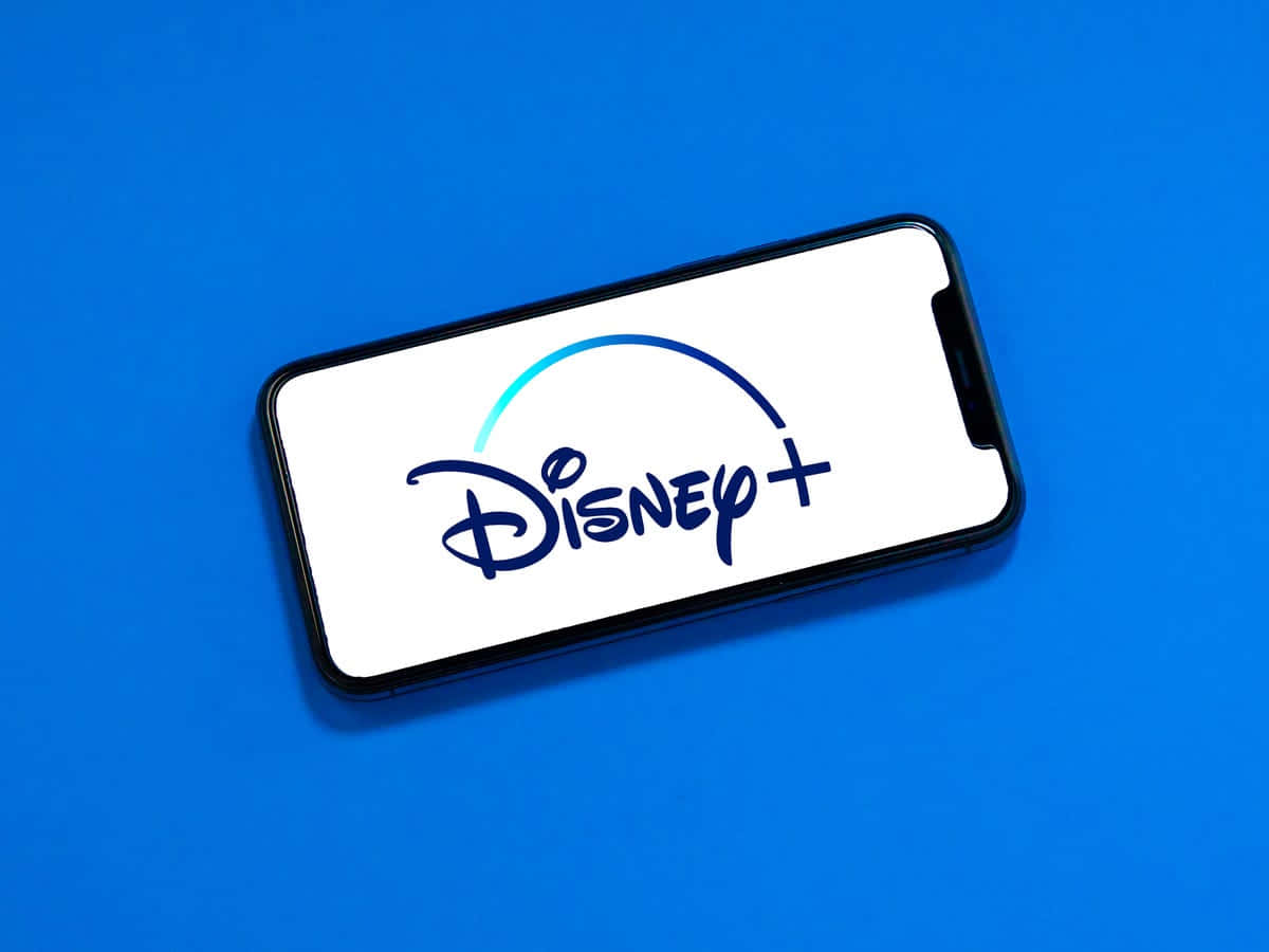 Disney Plus 桌布 壁紙 — 一部智能手機在充滿活力的藍色背景上顯示Disney+標誌，設計簡潔極簡。