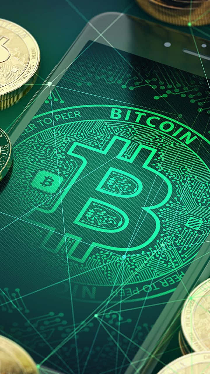加密貨幣 桌布 壁紙 — 一部智能手機在電路上顯示發光的綠色Bitcoin標誌，周圍散落著實體金幣。