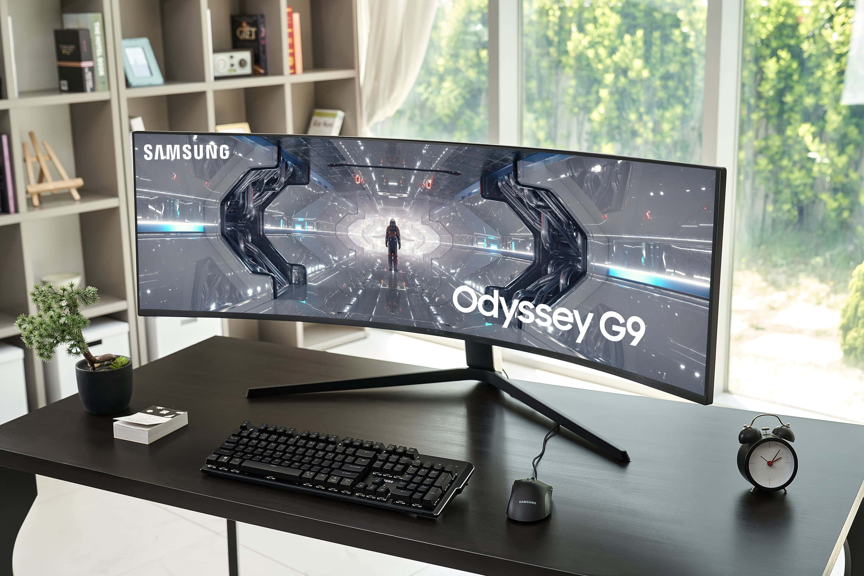 Gaming Monitors 桌布 壁紙 — 一部曲面Samsung Odyssey G9顯示器在時尚的黑色桌上展示未來科幻場景，配有鍵盤、滑鼠和盆栽植物。