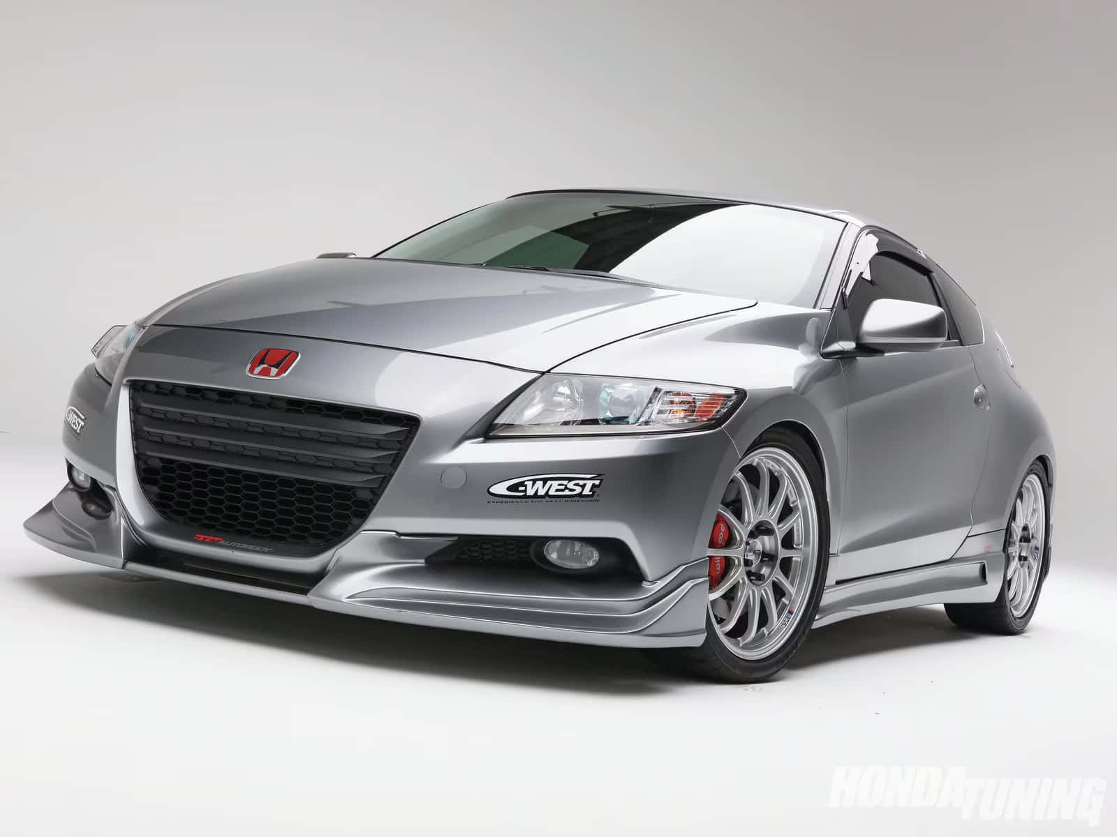 Honda Cr-z 桌布 壁紙 — 一部線條流暢的銀色本田轎跑車，配備定制改裝零件和紅色制動卡鉗，在純白色工作室背景前擺拍。