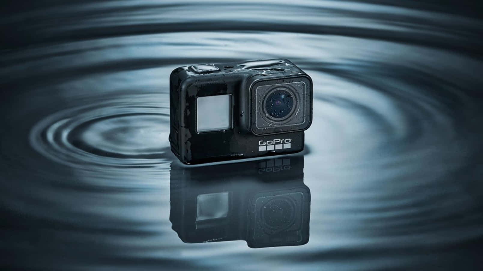 gopro 桌布 壁紙 — 一部黑色GoPro相機漂浮在水中，周圍有同心圓漣漪向外擴散。