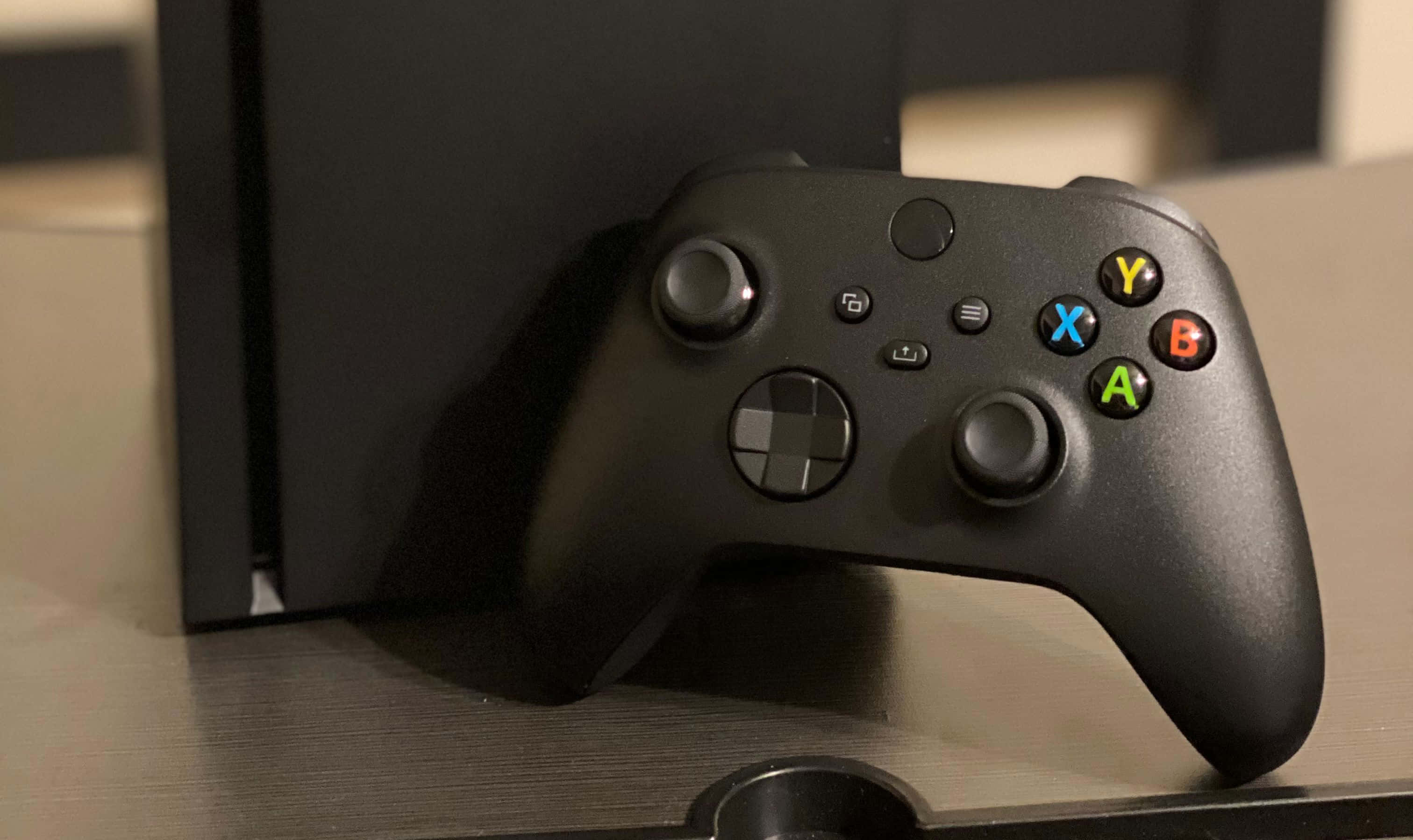一部黑色Xbox One主機放在桌上 壁紙