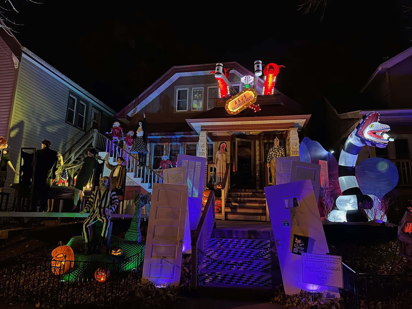 Halloween Yard Decorations 桌布 壁紙 — 一間夜晚的房子，奢華地裝飾著發光的萬聖節道具，包括骷髏、南瓜和一個巨大的充氣鱷魚。