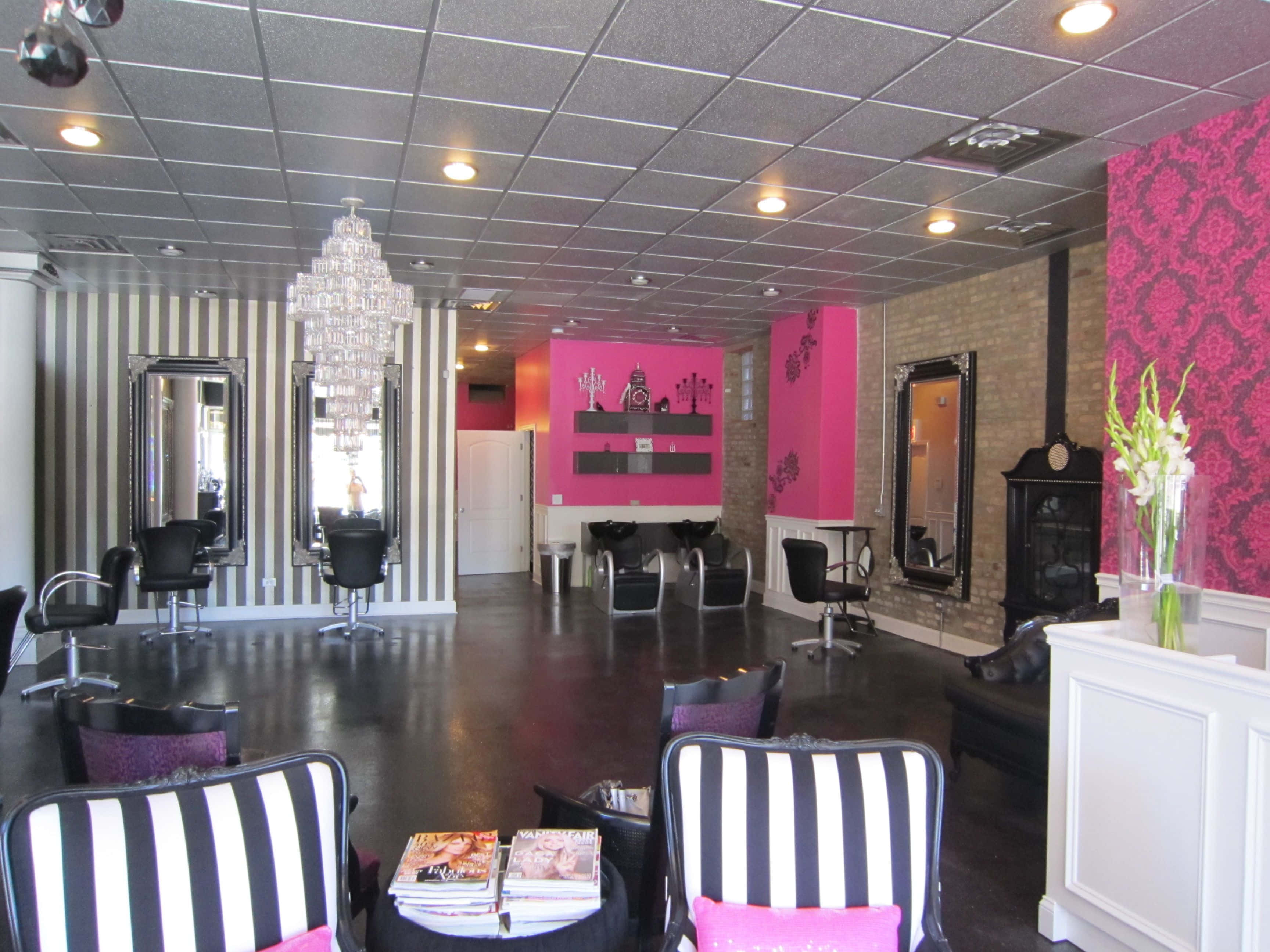 Hair Salon 桌布 壁紙 — 一間時尚沙龍，擁有黑白條紋牆壁、粉紅色點綴，以及懸掛在時尚造型椅上的水晶吊燈。