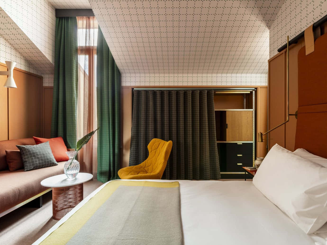 Hotel Room 桌布 壁紙 — 一間時尚現代酒店客房，配有芥末黃色椅子、綠色窗簾和溫暖的木質裝飾，沐浴在自然光中。