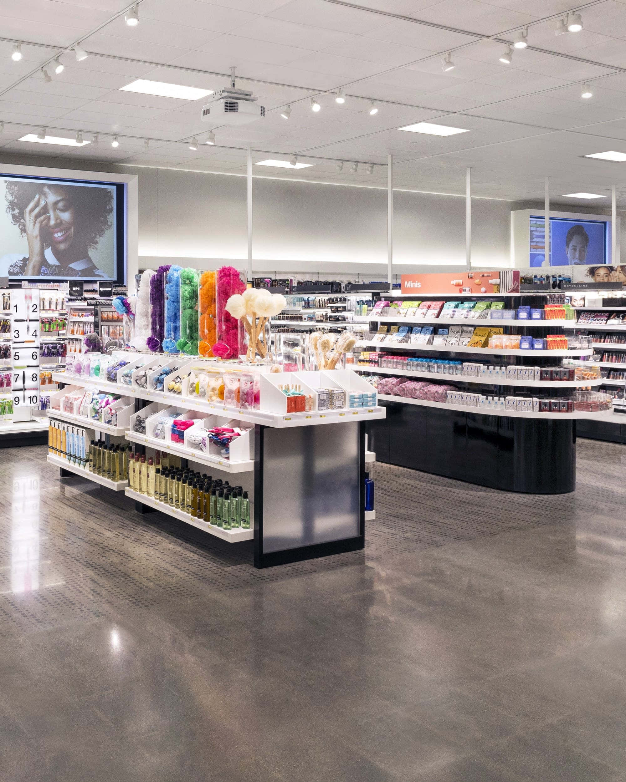 Shop 桌布 壁紙 — 一間燈光明亮的化妝品店，設有色彩繽紛的產品展示和顯示美容廣告的大型屏幕。