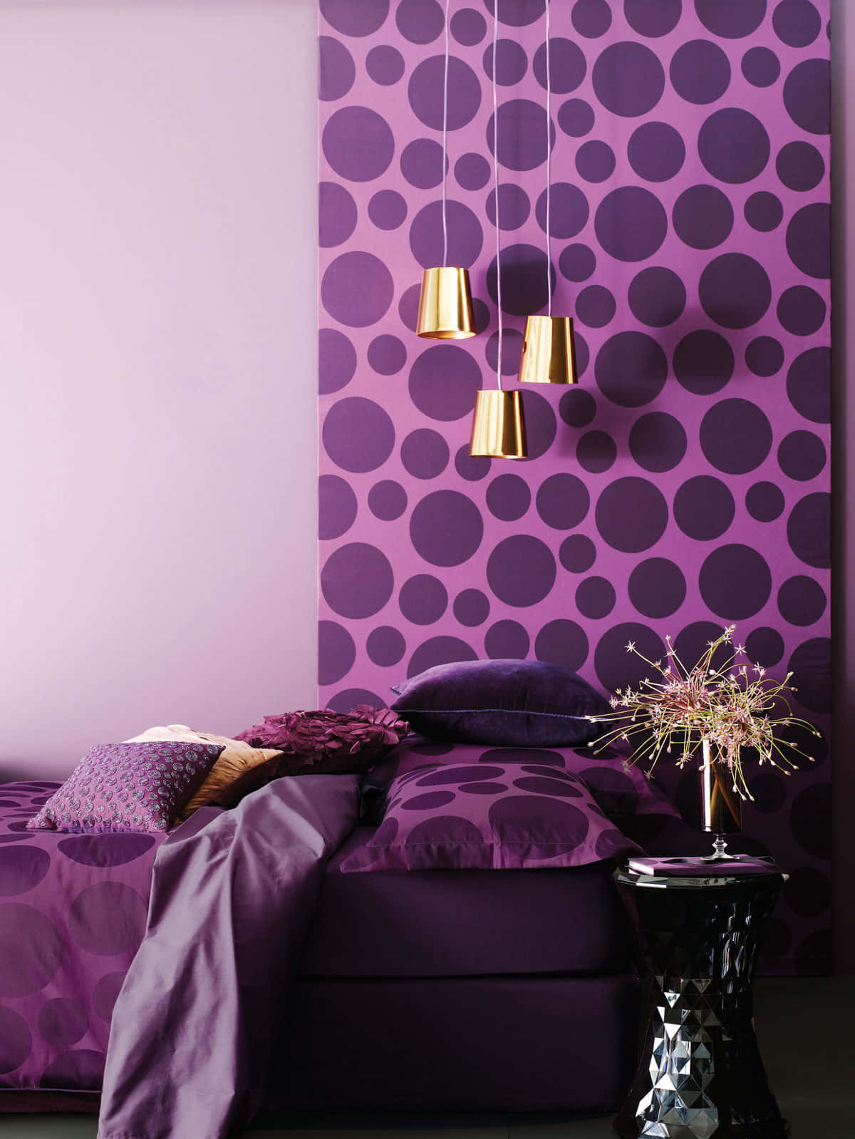 Purple Decor 桌布 壁紙 — 一間臥室，配有紫色圓點牆紙和相配的床上用品，由金色吊燈照亮。
