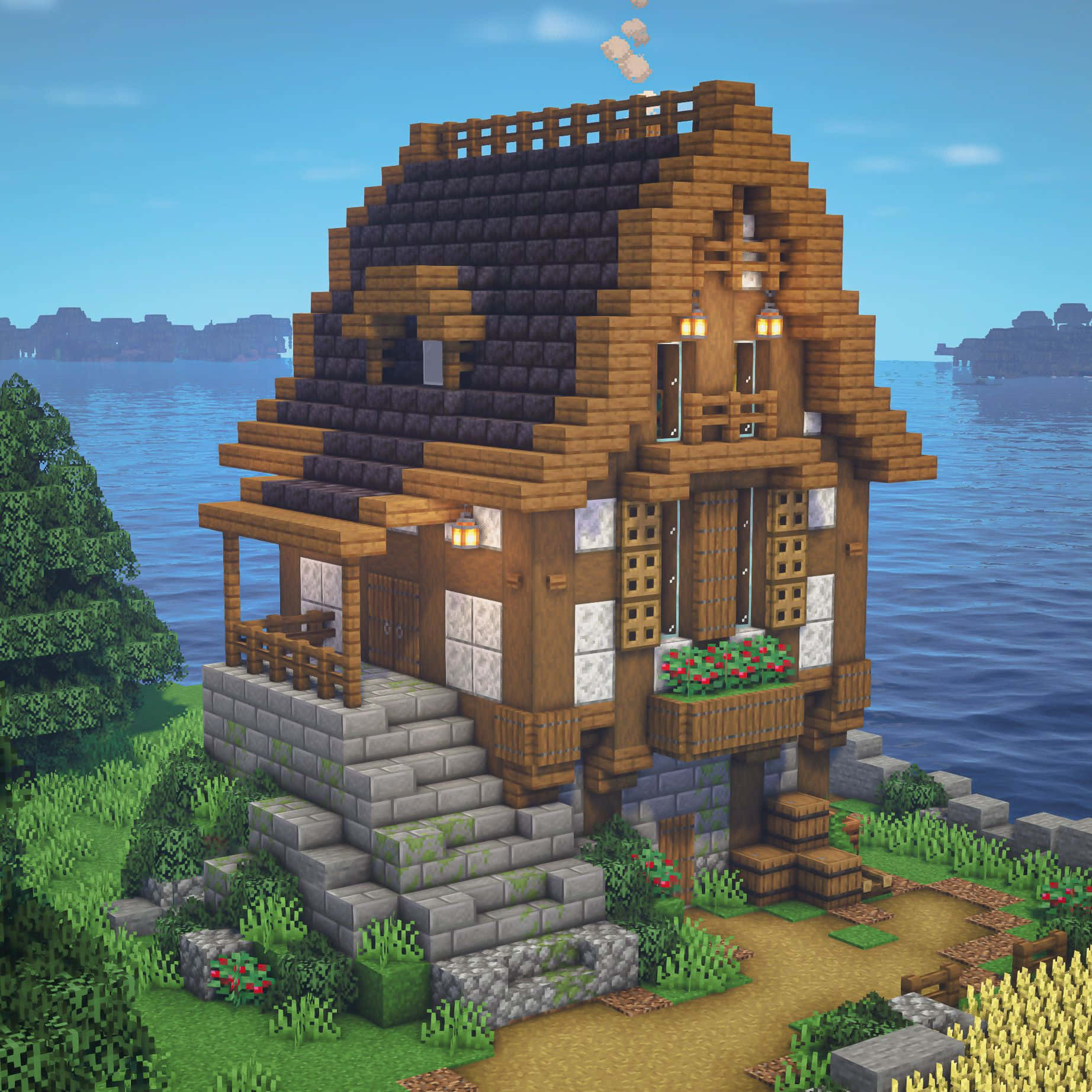 Minecraft Architecture 桌布 壁紙 — 一間舒適的像素風木屋，配有石頭地基和發光的燈籠，坐落在一個被綠意環繞的寧靜湖邊。