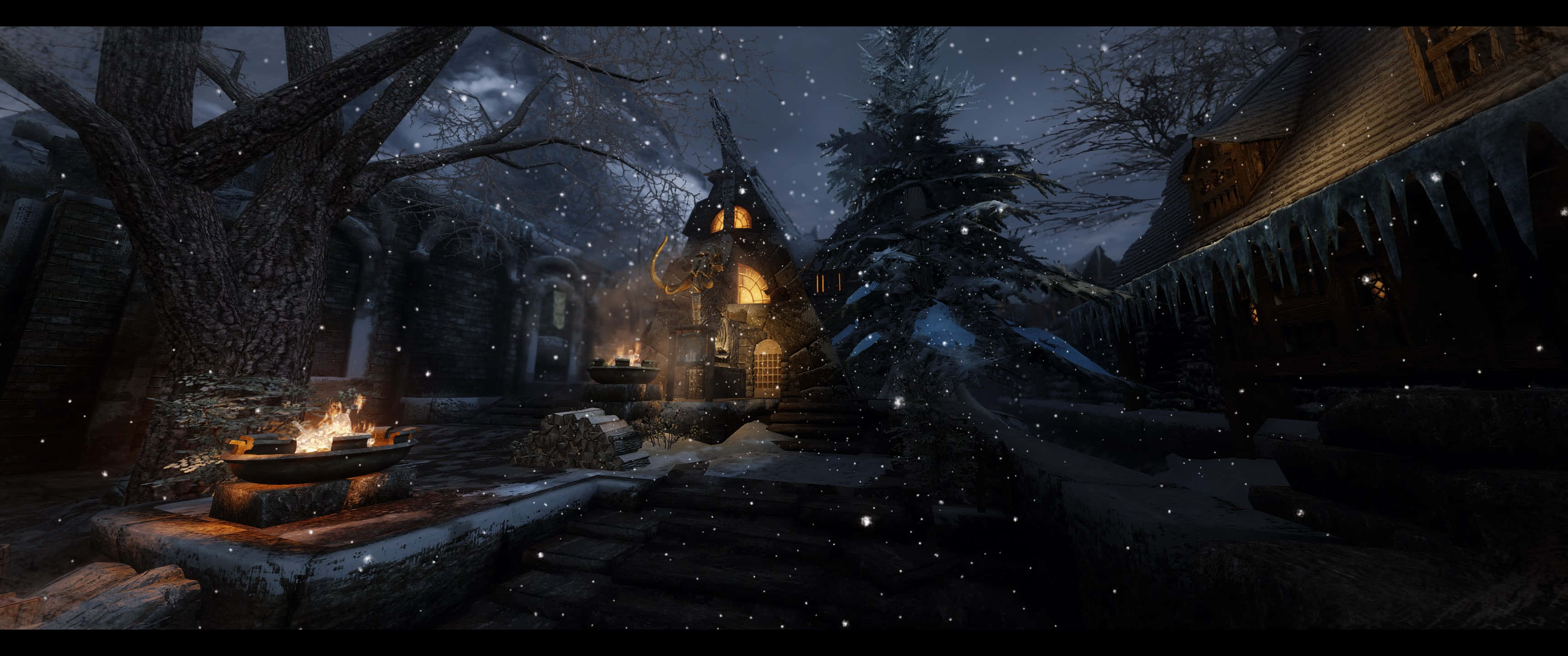 Skyrim Windhelm 桌布 壁紙 — 一間舒適的雪覆蓋小屋在星空下溫暖地發光，飄落的雪花和屋簷下的冰柱。