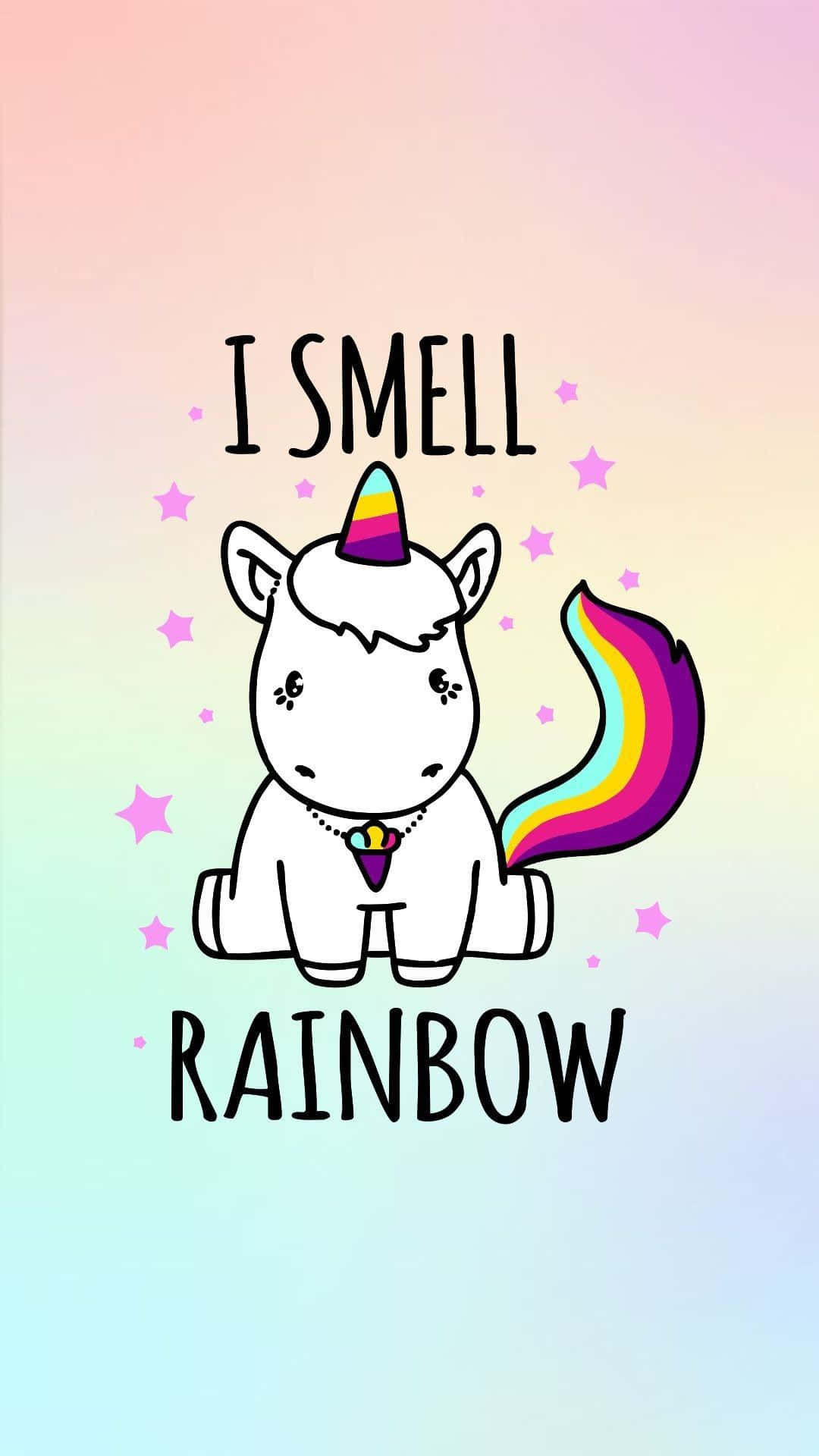 Kawaii Rainbow 桌布 壁紙 — 一隻可愛的卡通獨角獸，有彩虹角和尾巴，坐在有星星和文字寫著「我聞到彩虹」的粉彩漸變天空前。