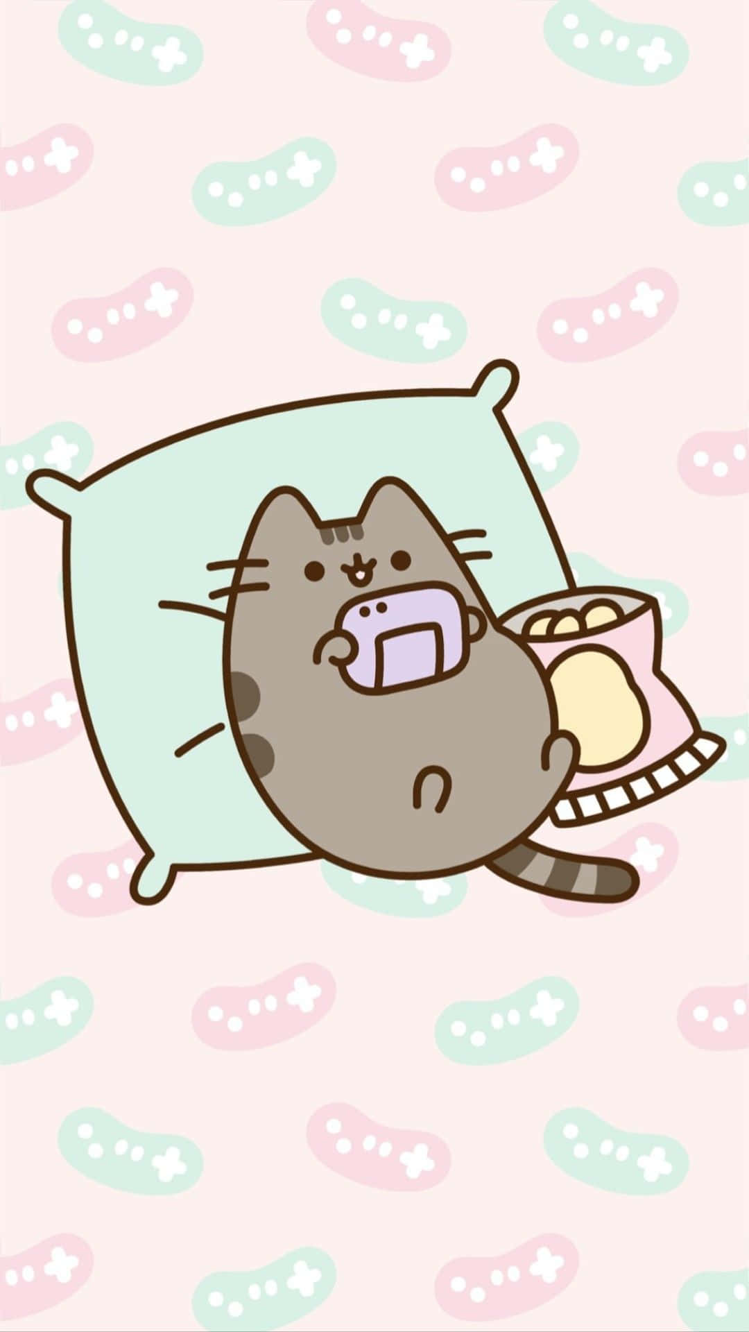 Kawaii Pusheen 桌布 壁紙 — 一隻可愛的卡通貓咪躺在枕頭上，拿著手機和零食袋，背景是粉彩圖案。