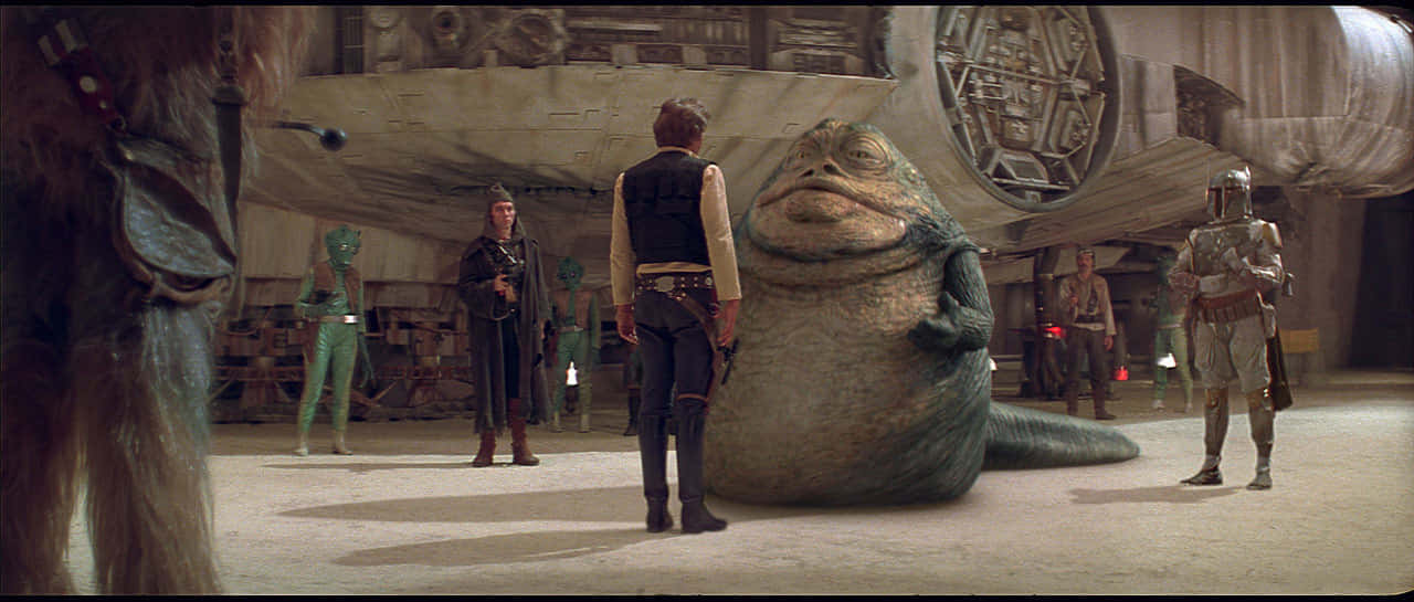 A New Hope 桌布 壁紙 — 一隻大型綠色蛞蝓狀生物平靜地坐在太空船機庫中，周圍站著各種外星角色。