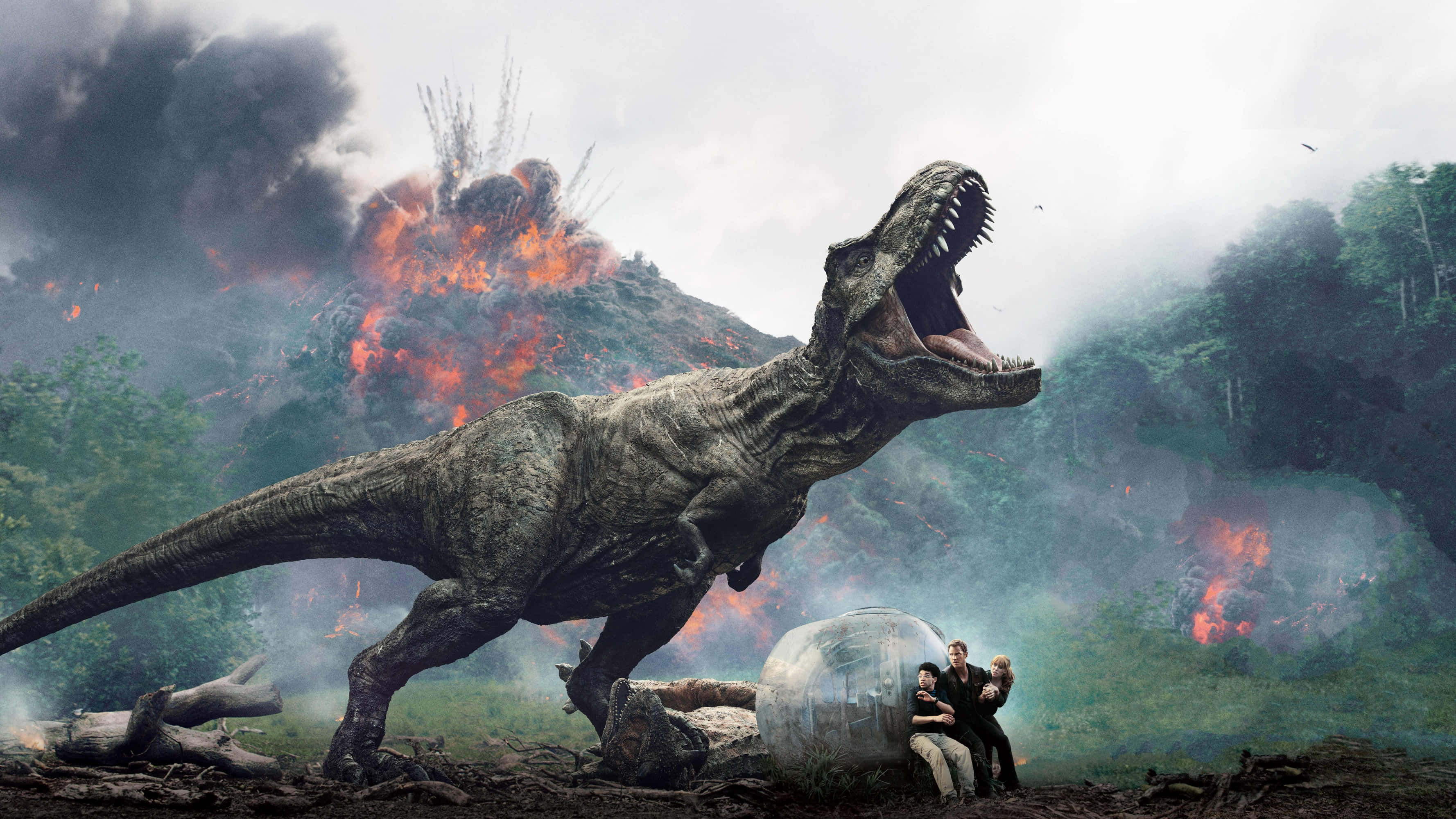 Jurassic World 桌布 壁紙 — 一隻巨大的咆哮暴龍統治著熾熱的火山景觀，而三個人則平靜地坐在附近的透明球體中。