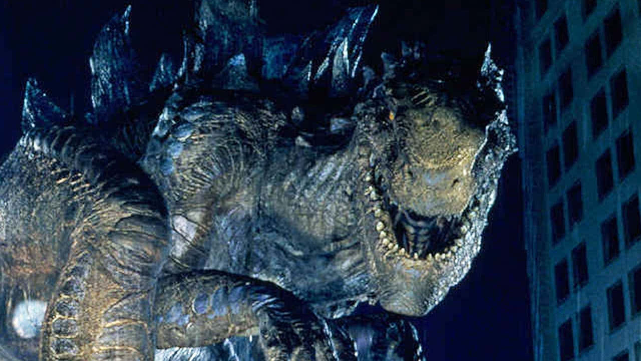 godzilla 1998 桌布 壁紙 — 一隻巨大的哥斯拉在夜間籠罩著城市，眼睛發光，背鰭呈鋸齒狀。
