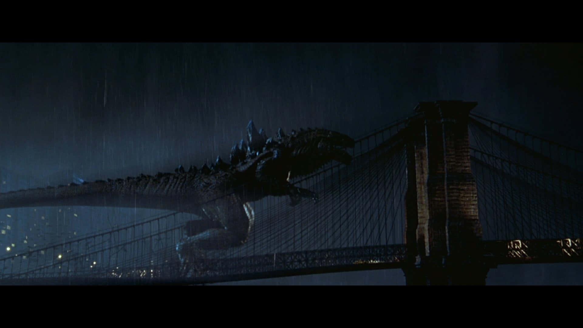 godzilla 1998 桌布 壁紙 — 一隻巨大的哥斯拉在黑暗暴風雨的夜空下，大步走過濕滑的吊橋。