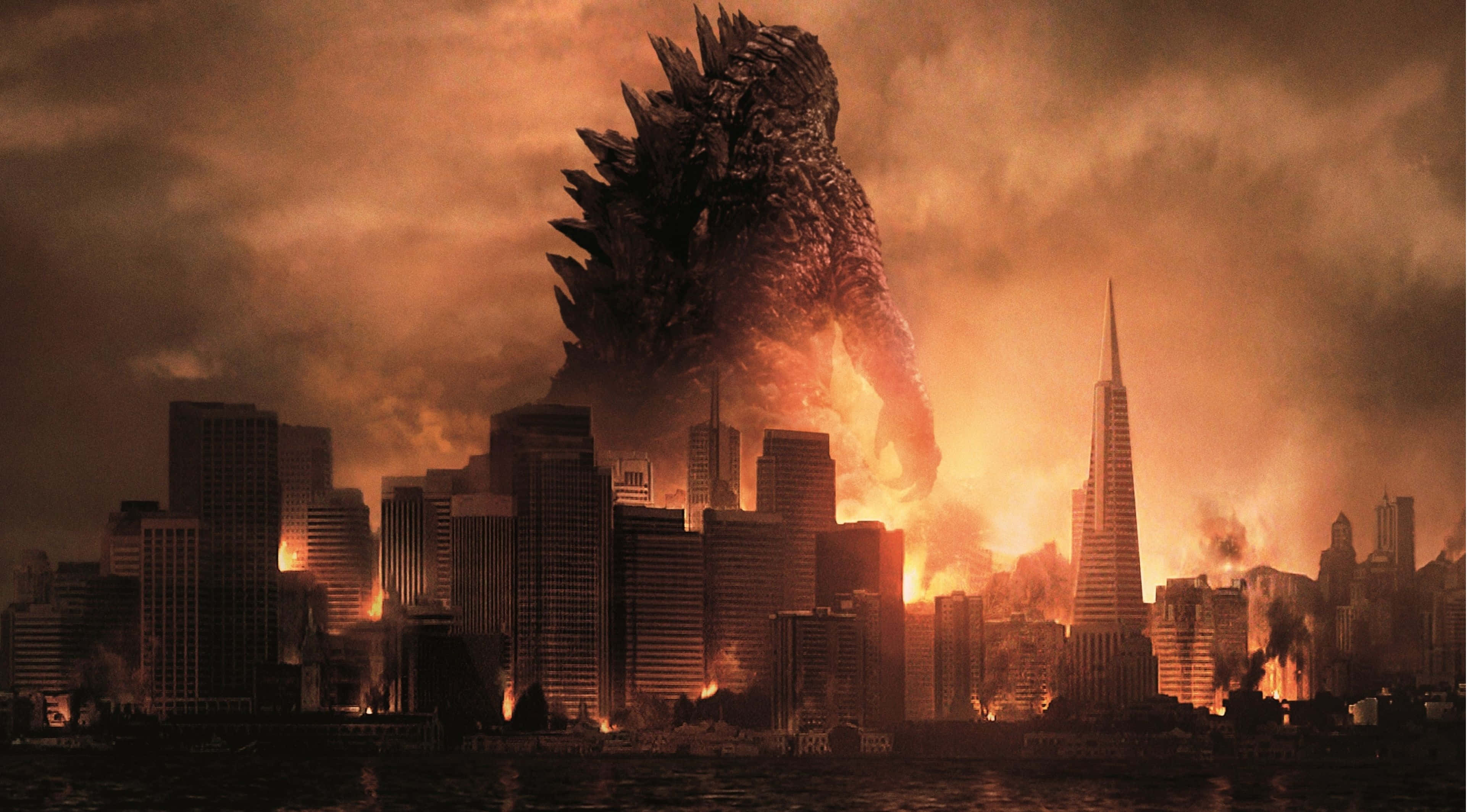Godzilla 2014 桌布 壁紙 — 一隻巨大的哥斯拉聳立在燃燒的城市景觀之上，摩天大樓在烈火和濃煙中倒塌。