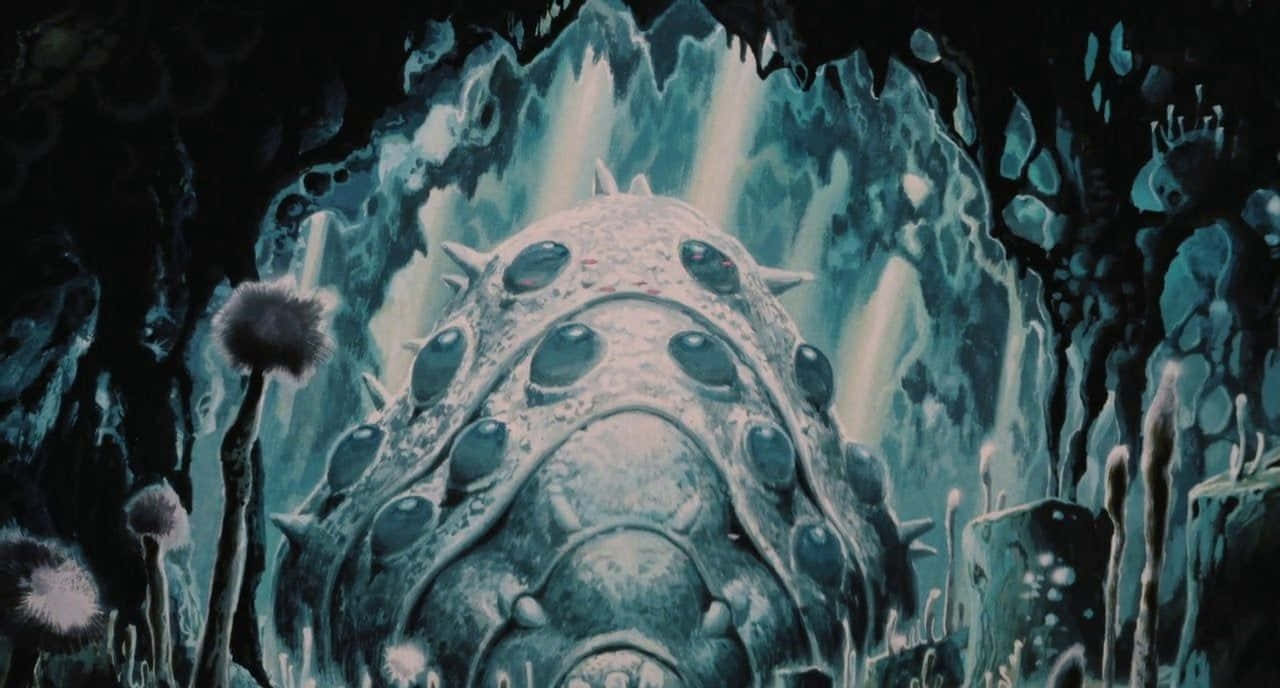 nausicaä of the valley of the wind 桌布 壁紙 — 一隻巨大的多眼尖刺生物從一個由發光鐘乳石照亮的深藍色洞穴中出現。