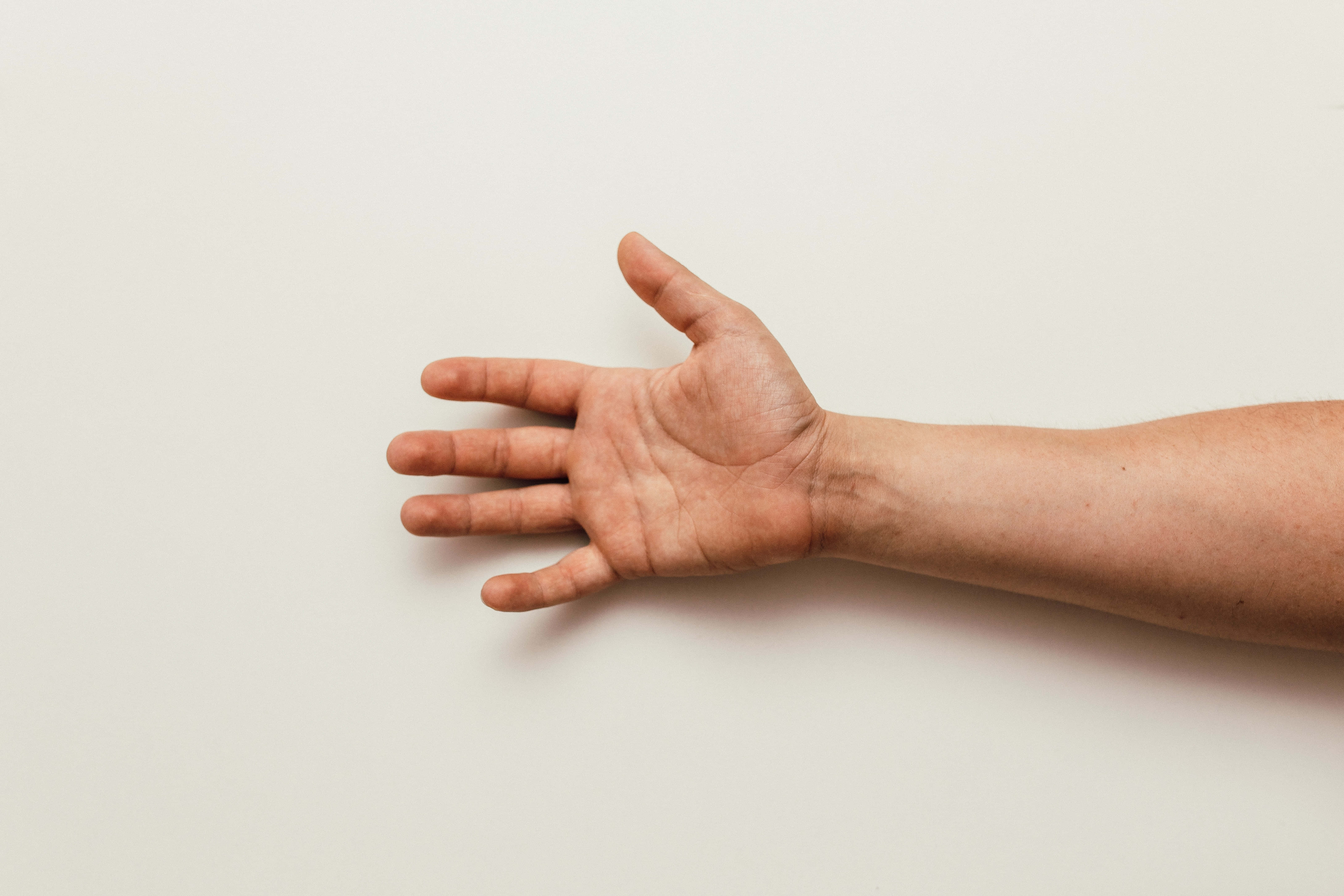 hands 桌布 壁紙 — 一隻張開的人手特寫，背景為純米白色，光線柔和。